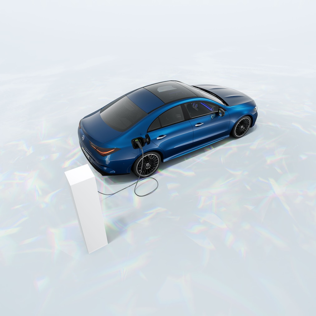 View of a Mercedes-Benz CLA 250 e Coupé with EQ hybrid technology standing at a charging station.