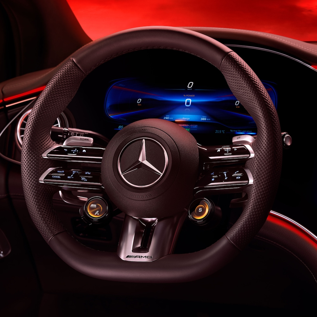 View on the AMG Performance steering wheel, seen from the driver's seat against a red background.