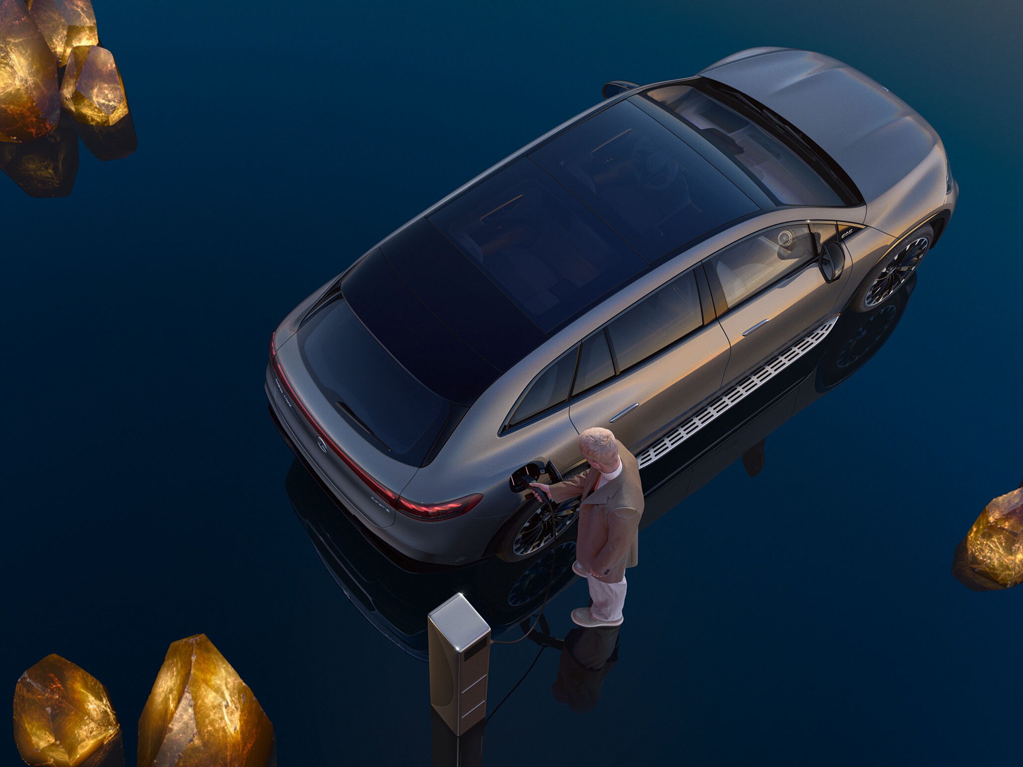 Birdseye view of man in brown jacket charging grey Mercedes-Benz