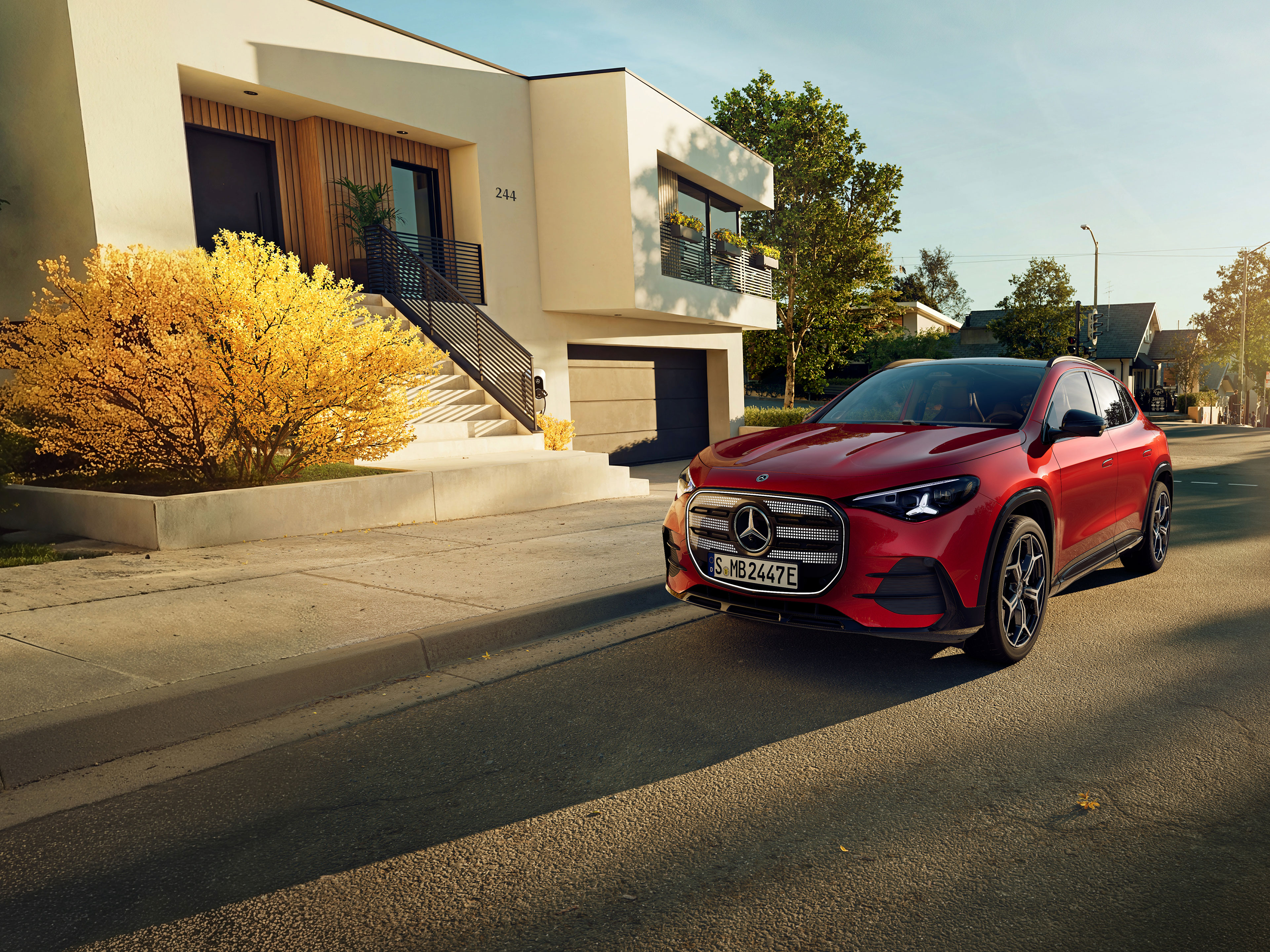 Exterior | The all-new electric GLA | Mercedes-Benz The all-new electric GLA from Mercedes-Benz parking in a parking space next to a coffee shop.