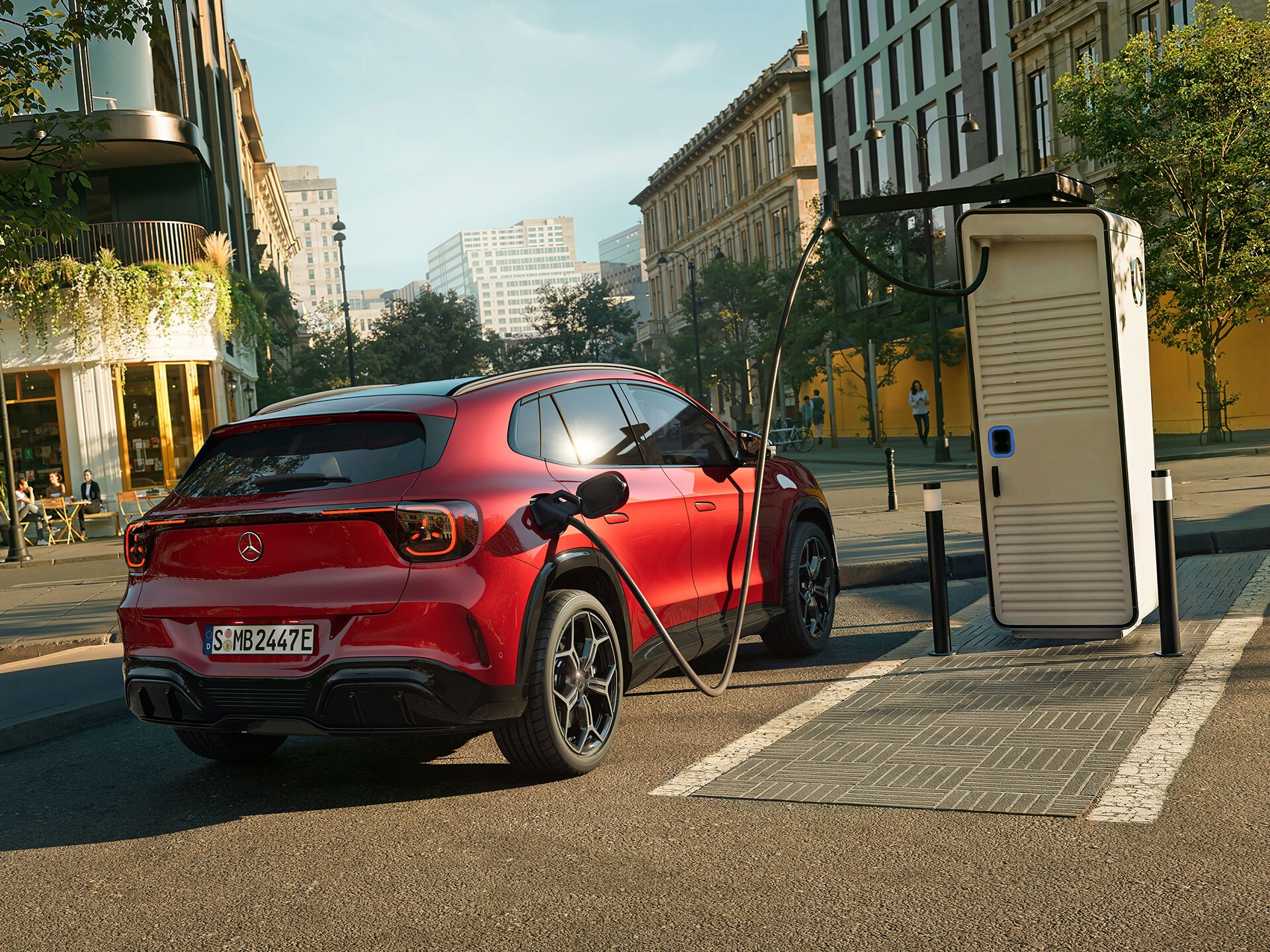 The all-new electric GLA from Mercedes-Benz standing next to a charging station while charging.