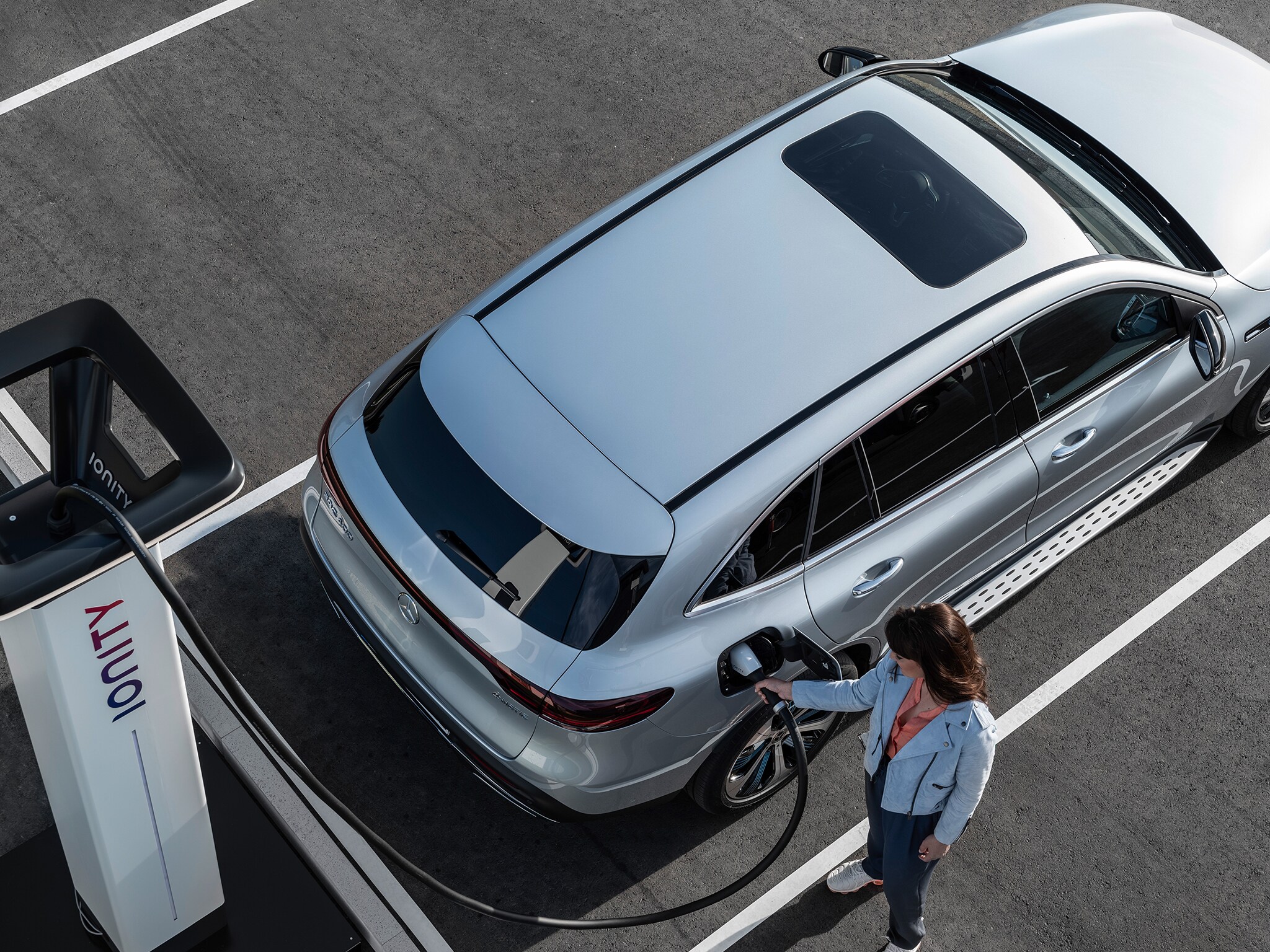 A person charging a Mercedes-Benz at an IONITY charging station