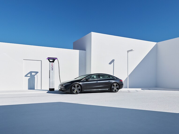A Mercedes-EQ EQS standing at a charging station.