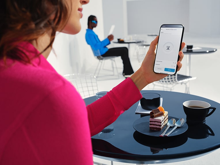 Woman holding her cell phone in her hand and using the Mercedes me App.