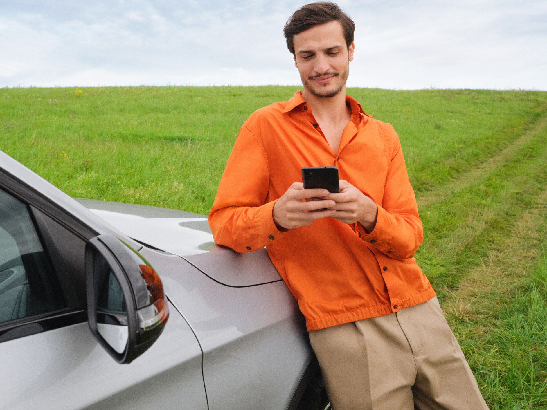 A man connects his smartphone to his vehicle to use the Standard Services.