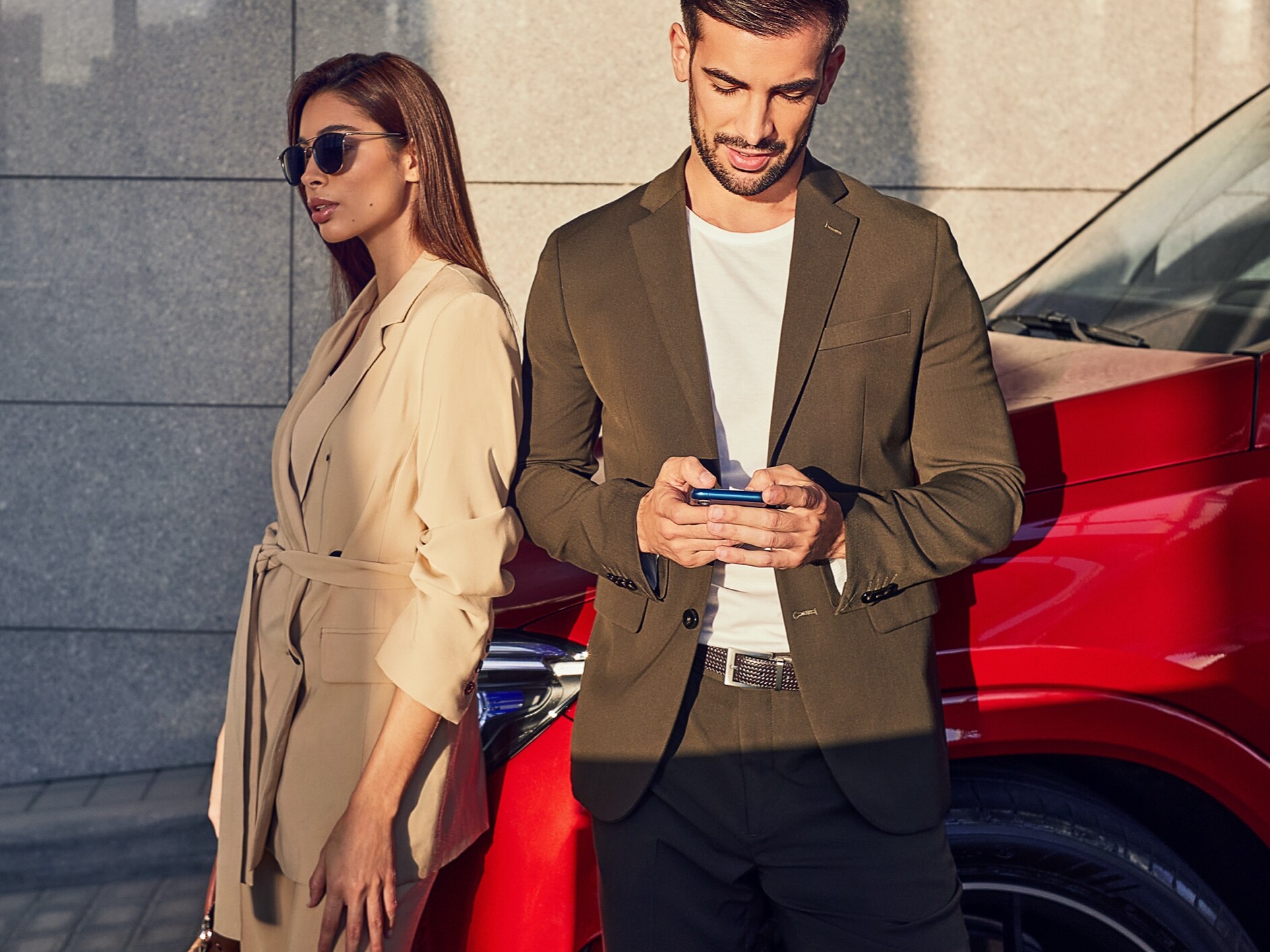 Two people renew/purchase Digital Extras for a vehicle via smartphone.