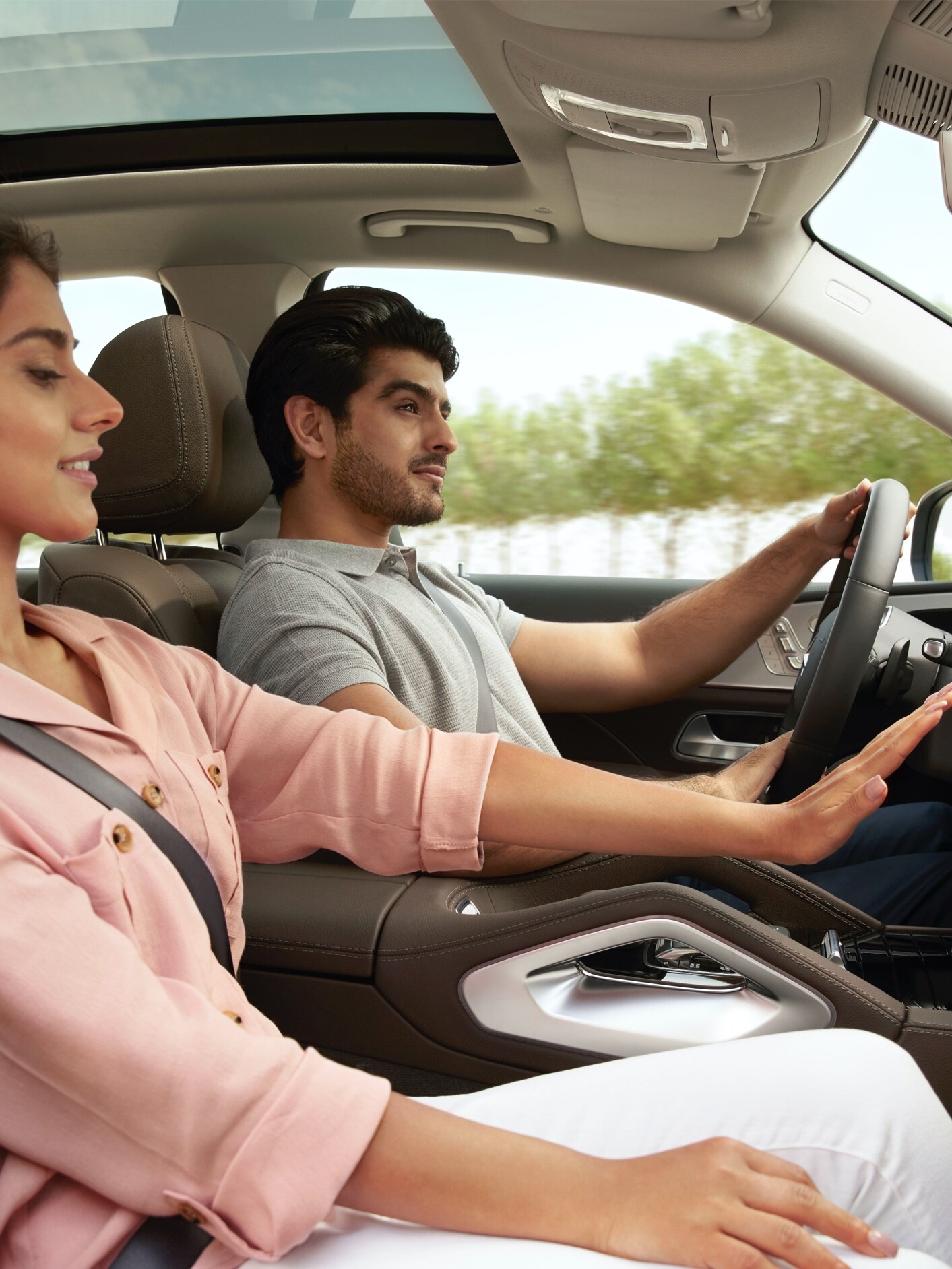A woman raises her hand in front of the air conditioning vents in her Mercedes-Benz.