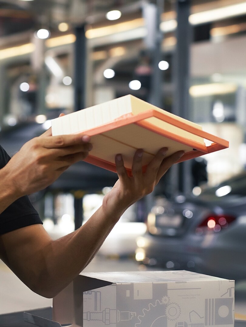 A Mercedes-Benz technician inspects an engine air filter.