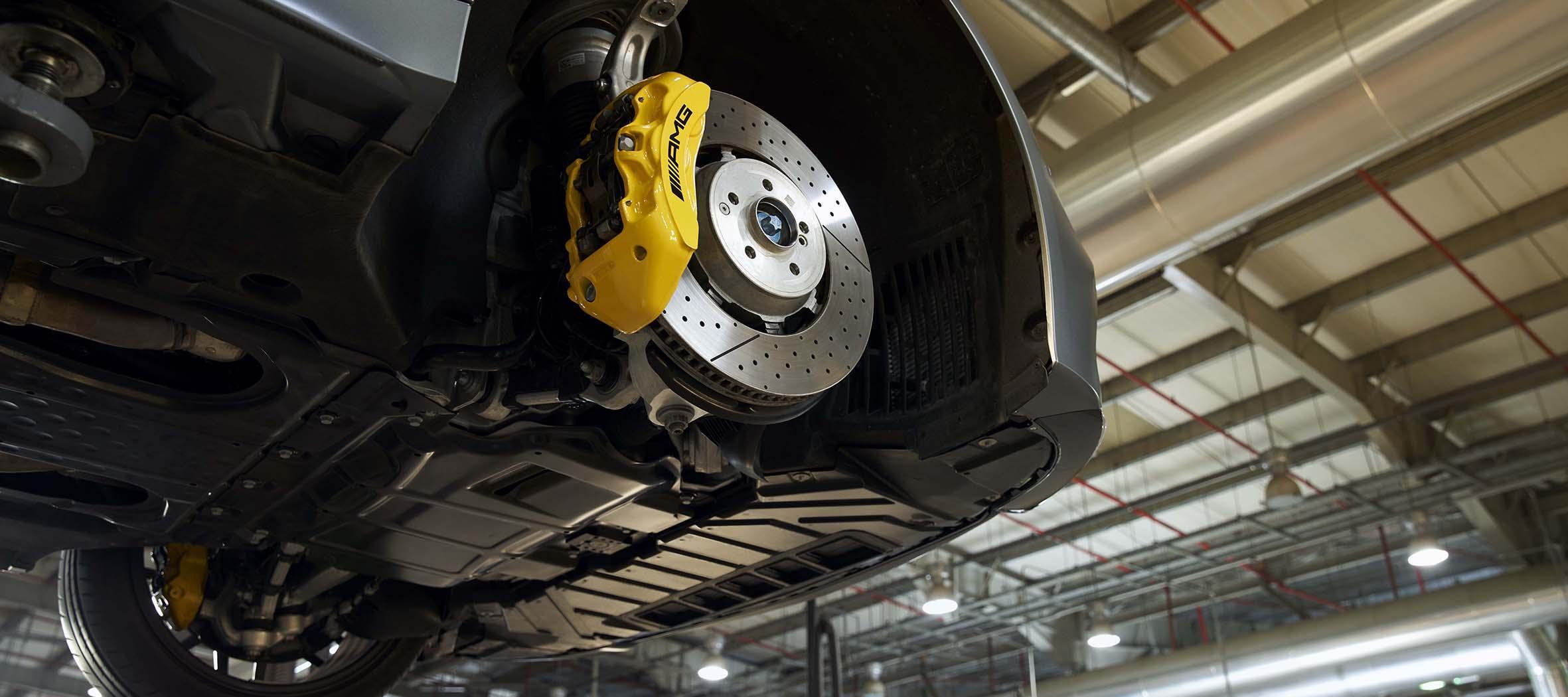 Mercedes-Benz replacement parts. A Mercedes-Benz technician checks the underside of a vehicle.