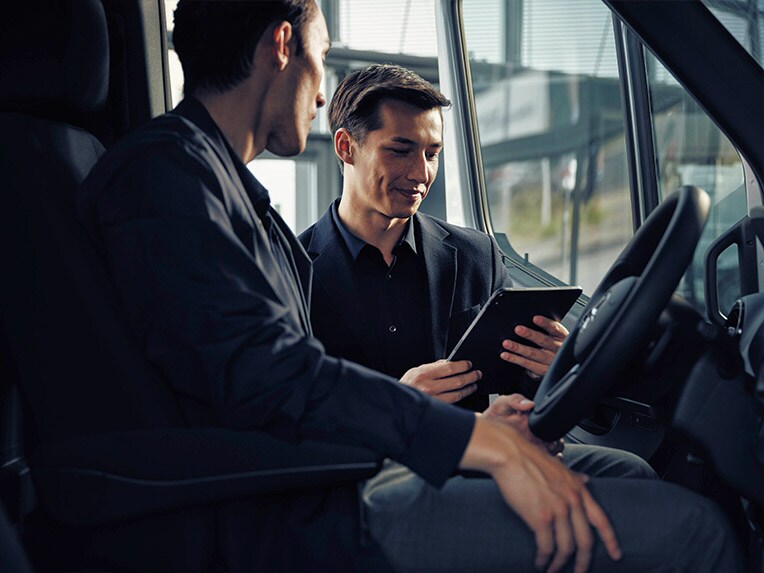 A man sitting in a Mercedes-Benz eSprinter talking to a dealer