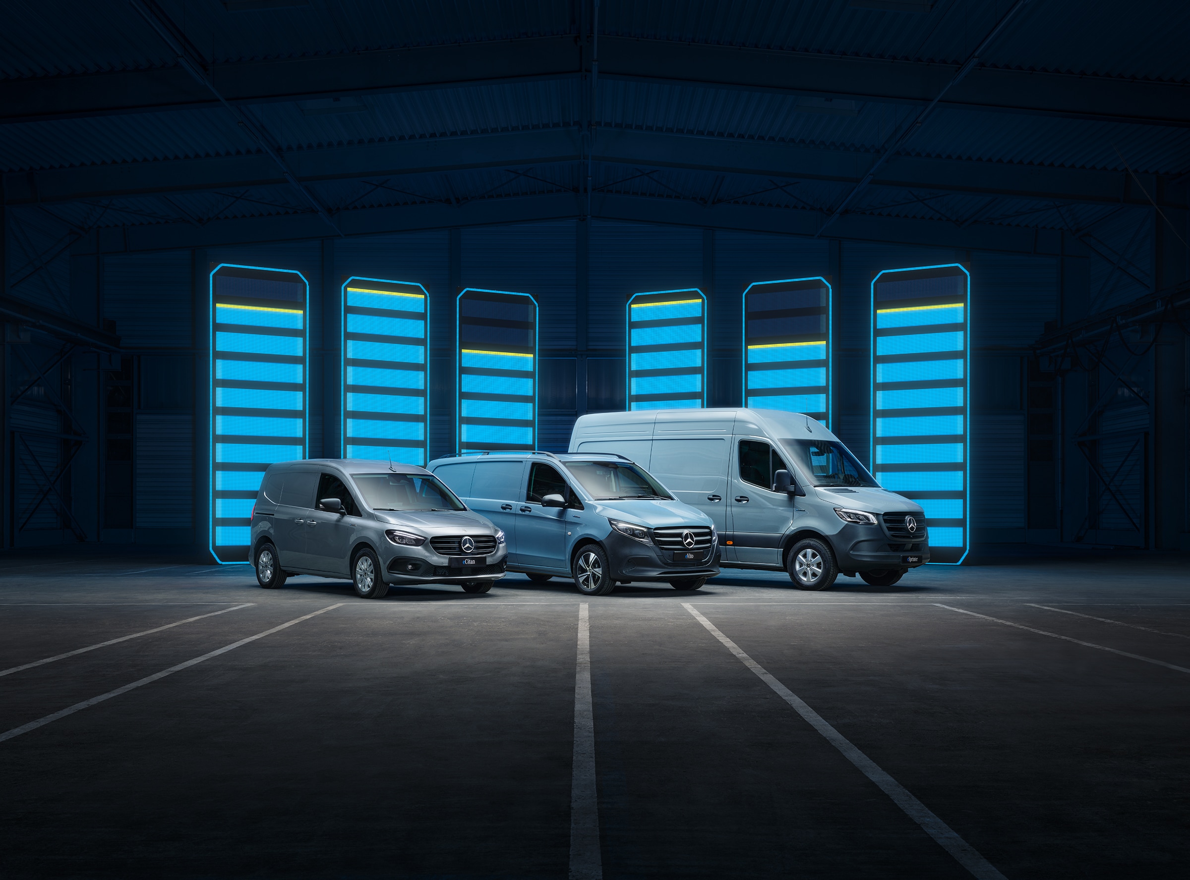 Mercedes-Benz electric van lineup | Commercial Vehicles History | Mercedes-Benz Mercedes-Benz electric van lineup displayed in futuristic warehouse with illuminated charging bars