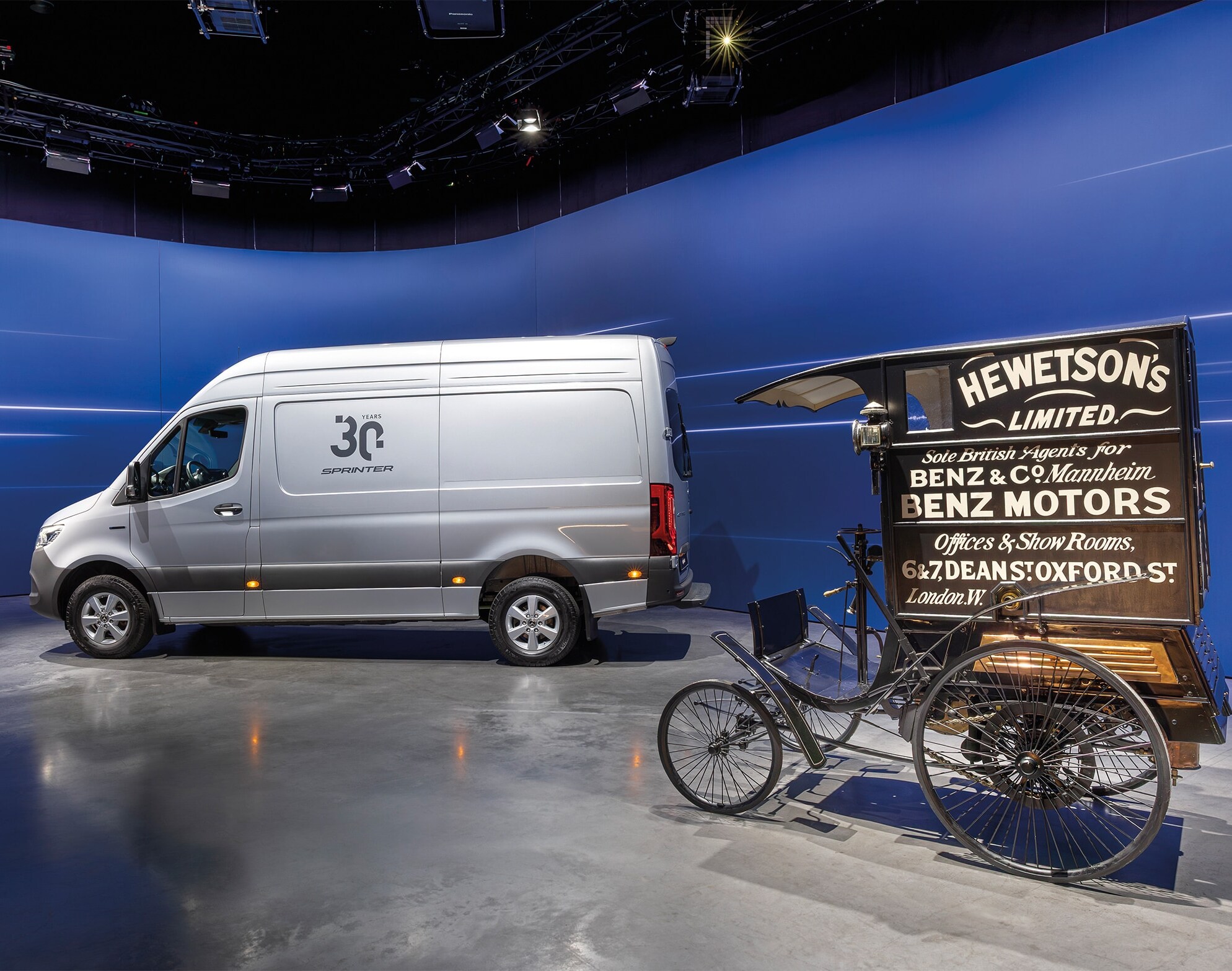 Mercedes-Benz Sprinter van and historic Benz delivery vehicle displayed in modern showroom