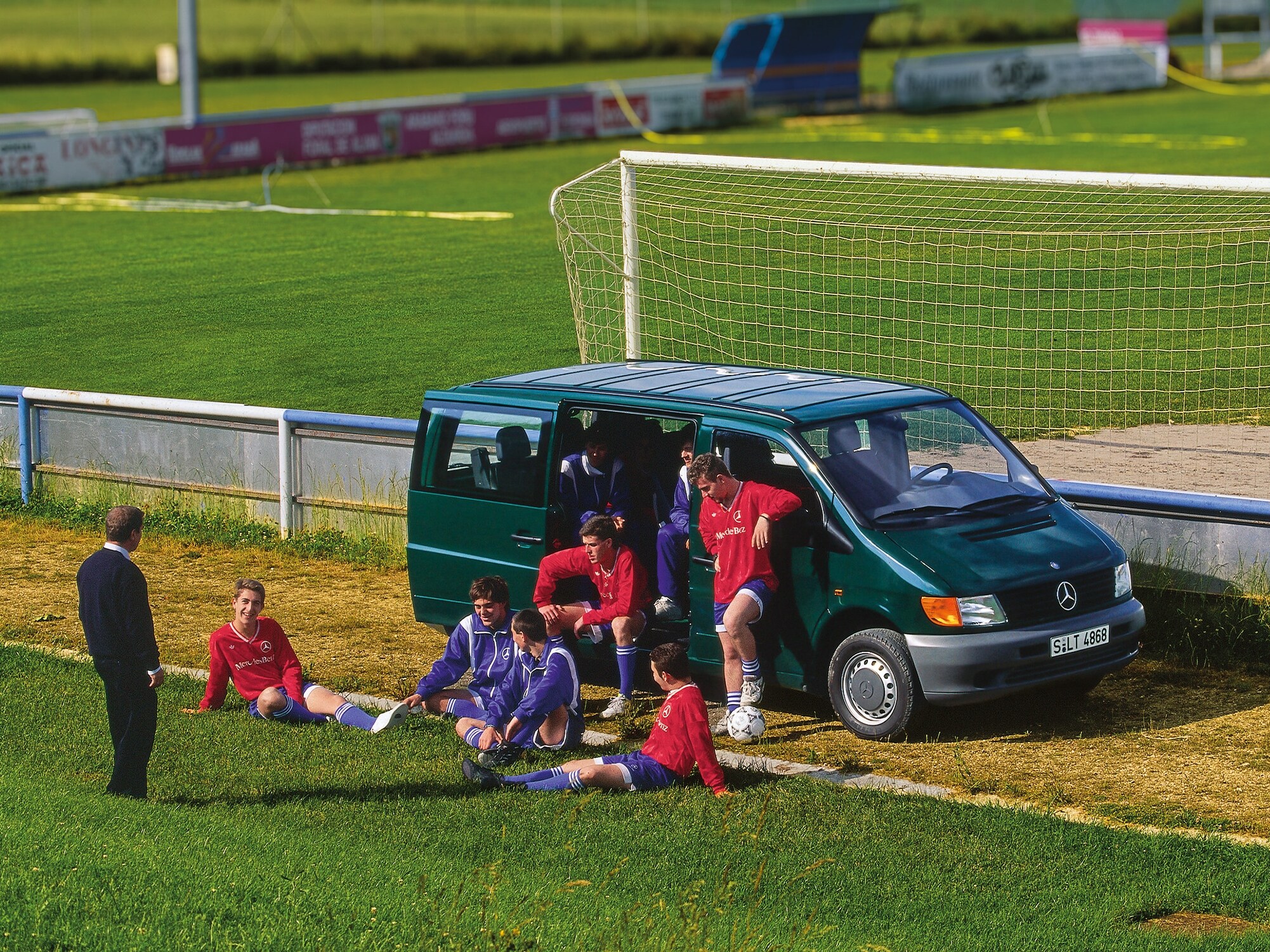 First generation Vito parked beside football field with team players nearby