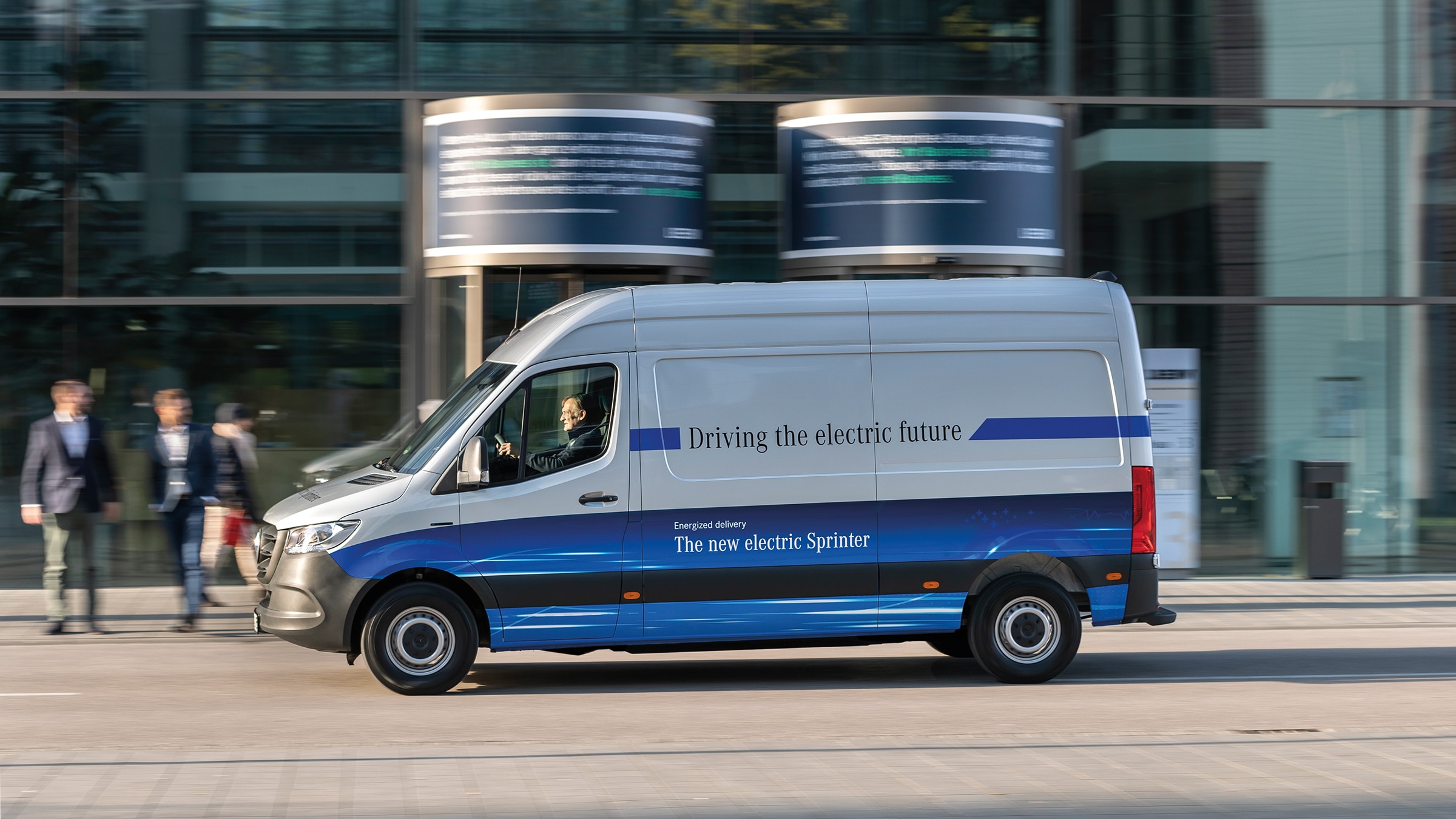 The second generation eSprinter Panel Van | Commercial Vehicles History | Mercedes-Benz Mercedes-Benz eSprinter Panel Van delivery van driving through modern city street