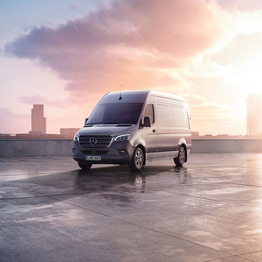 Grey Mercedes-Benz Sprinter on a black background, surrounded by confetti.