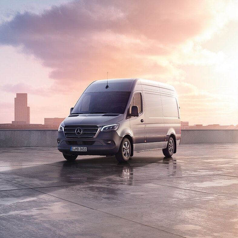 Grey Mercedes-Benz Sprinter on a black background, surrounded by confetti.