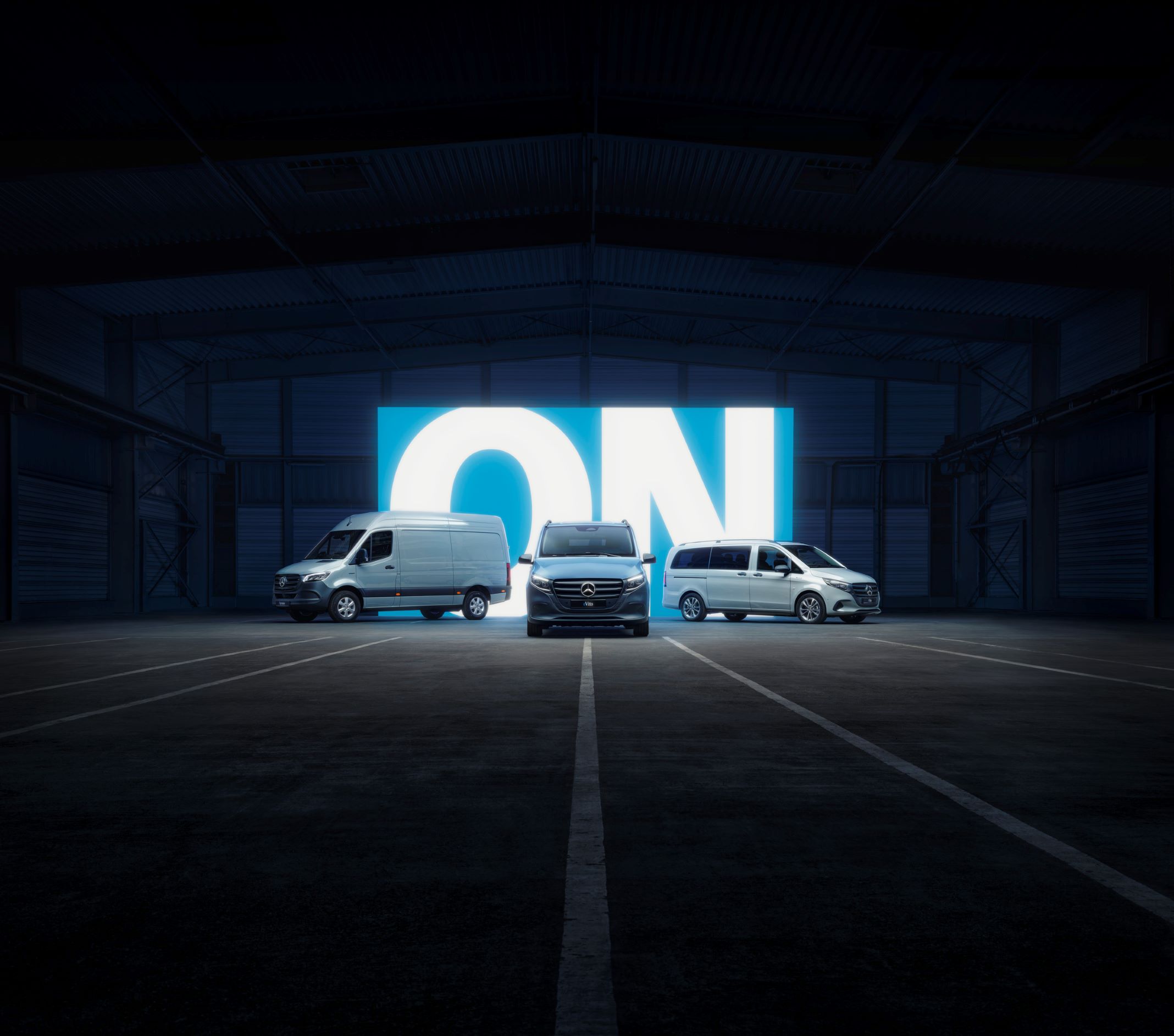 Vehicle features | MBUX multimedia system | Mercedes-Benz Mercedes-Benz electric vans in a dark setting with "ON" illuminated in the background.