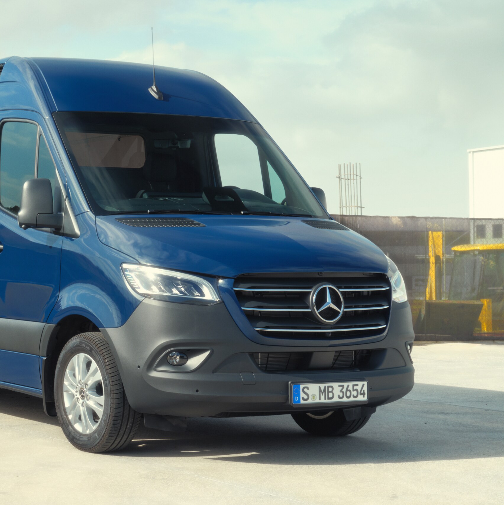 The Mercedes-Benz Sprinter Panel Van in front of building materials.