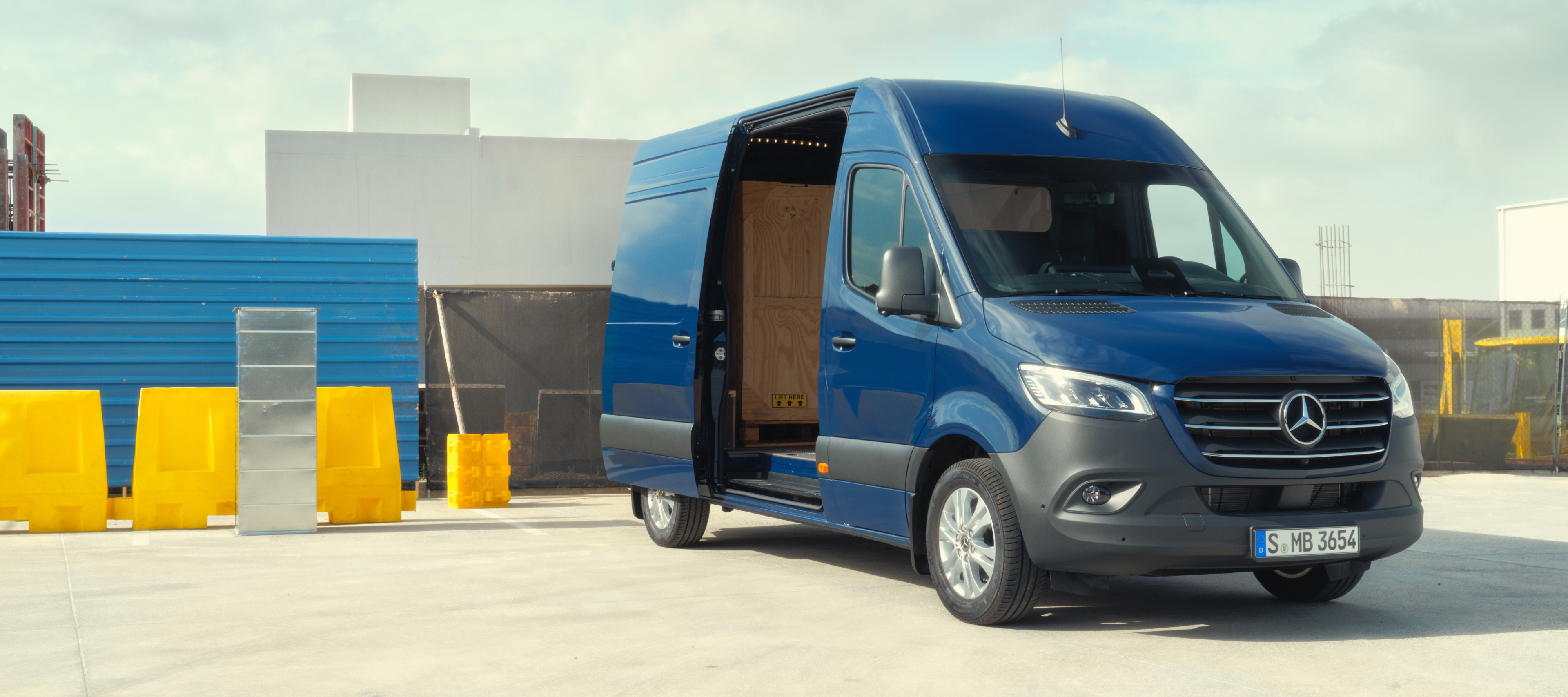 Vehicle comparison | Sprinter Panel Van | Mercedes-Benz The Mercedes-Benz Sprinter Panel Van in front of building materials.