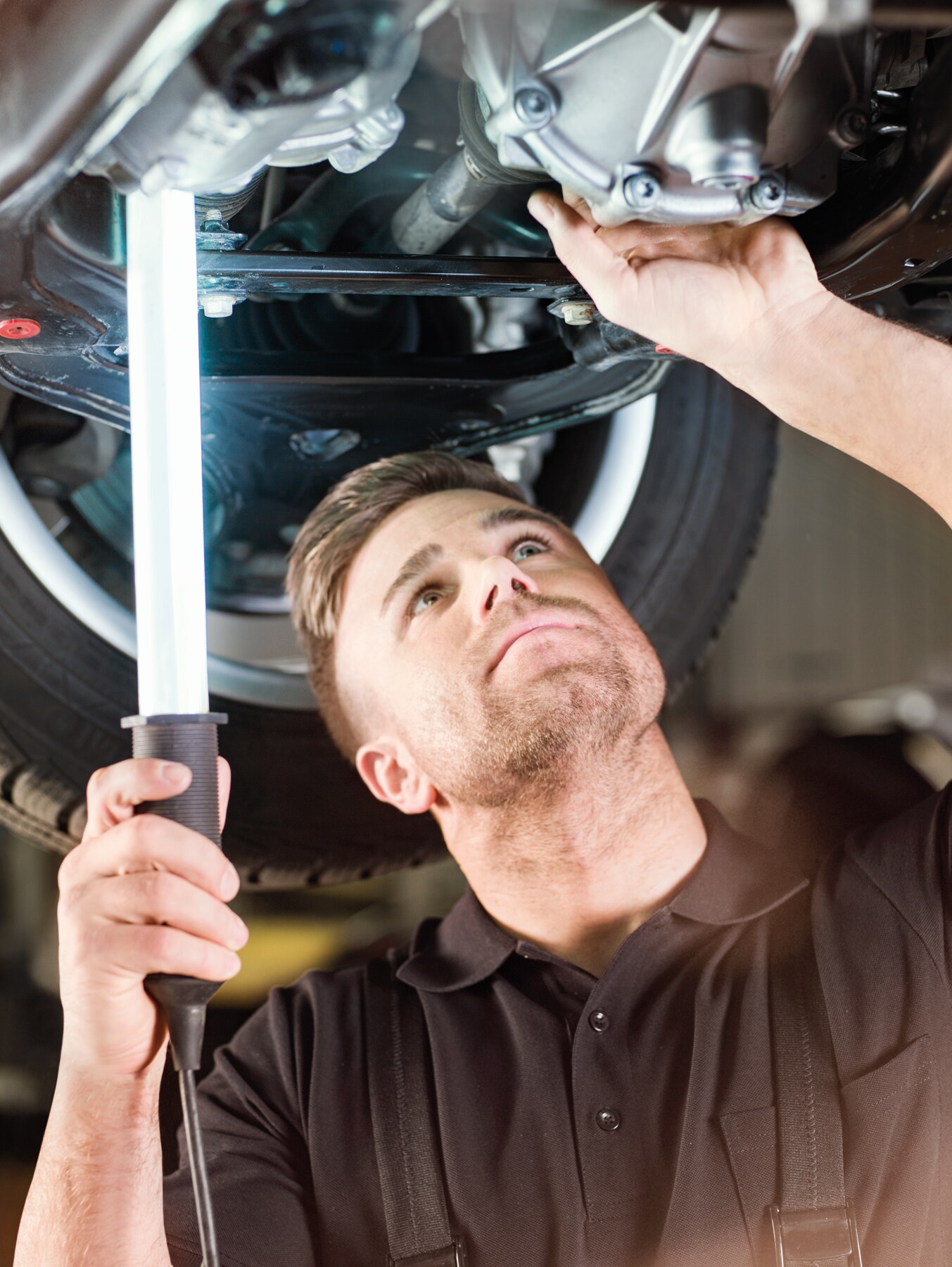 Three employees standing in front of a silver Mercedes-Benz eSprinter with charging cable attached.