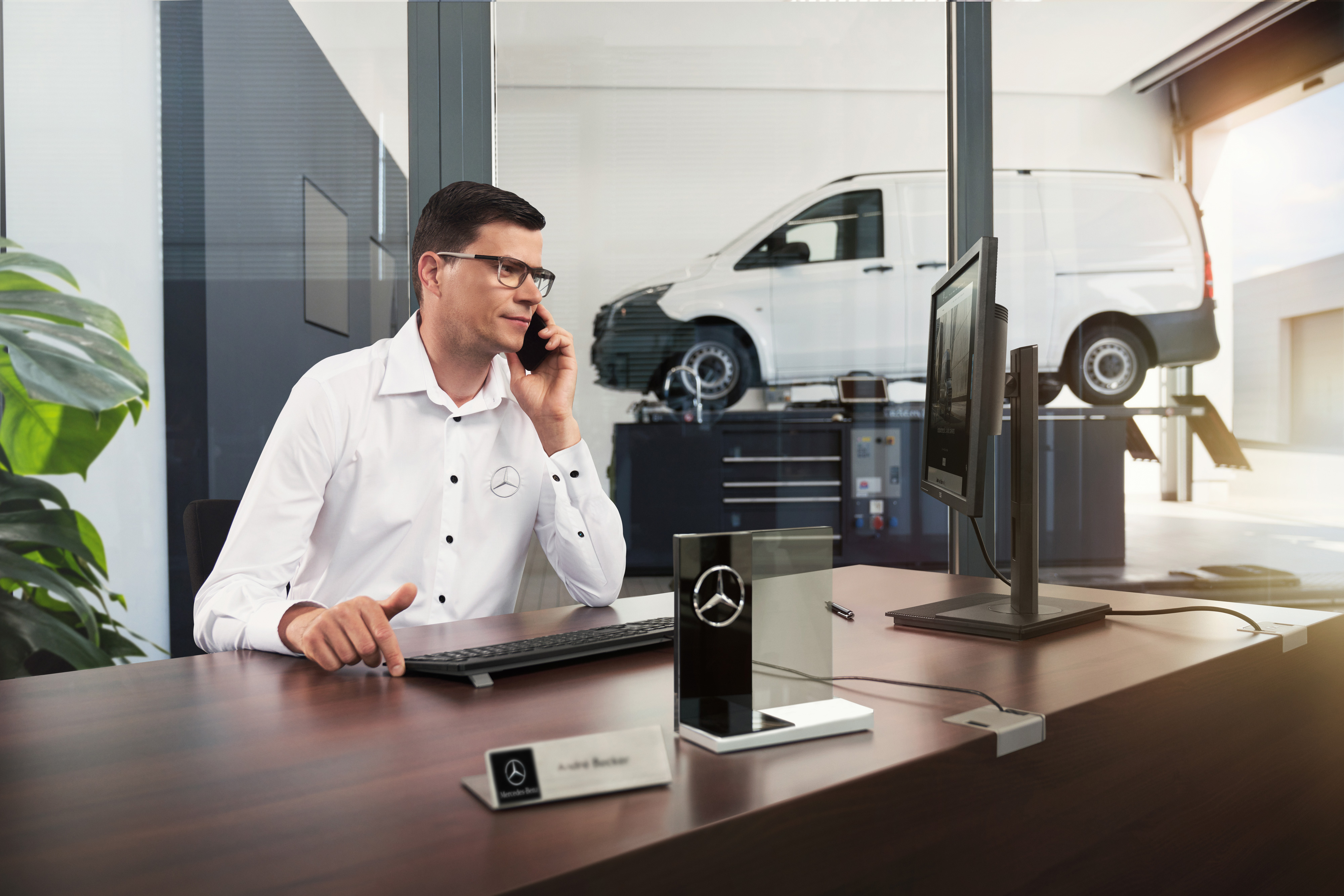 Mercedes-Benz | Convenience | Authorised Repairer Mercedes-Benz Service Adviser talking on the phone in a workshop.