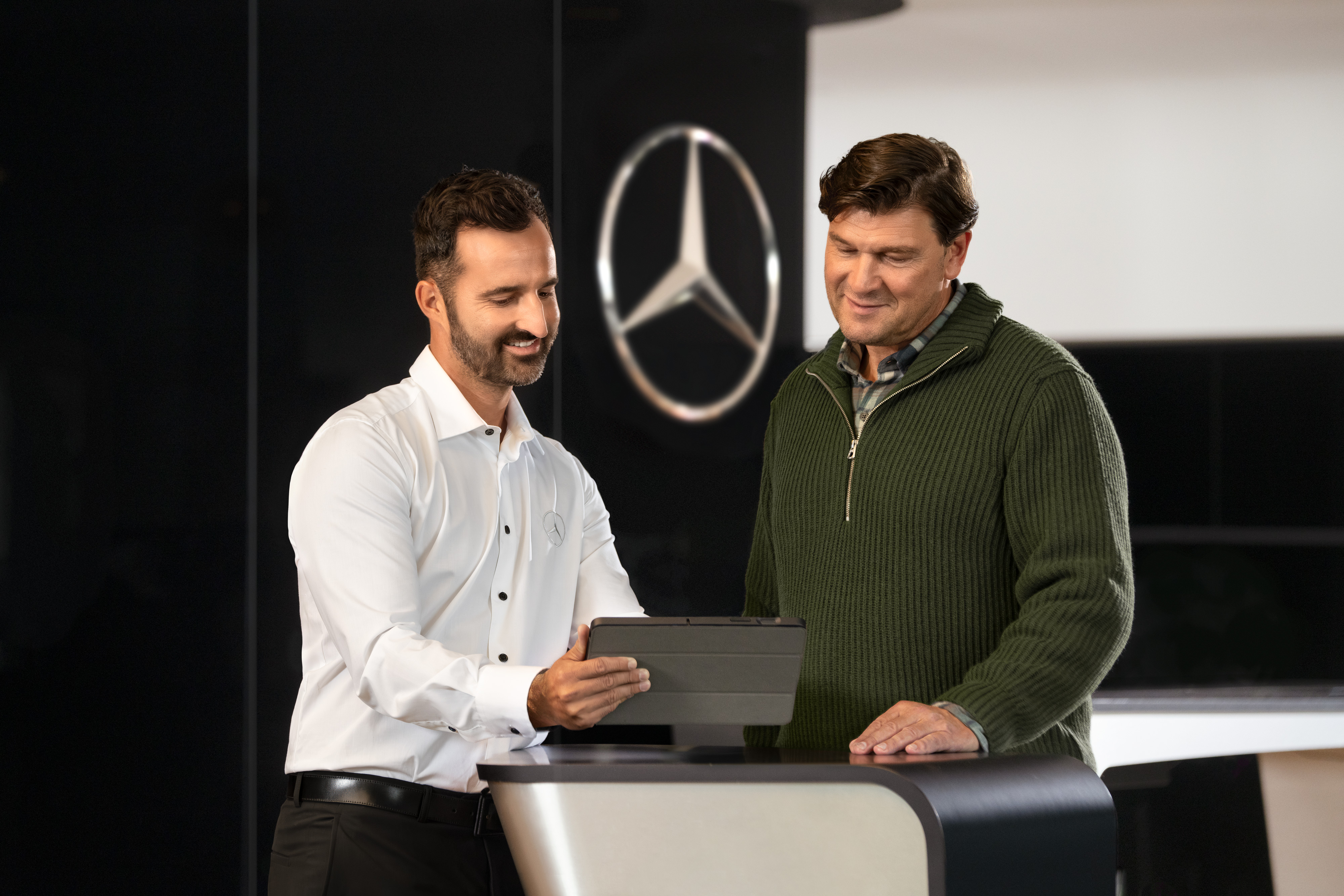 Mercedes-Benz | Convenience | Service Partner Mercedes-Benz employee talking to customer while looking at a table device.