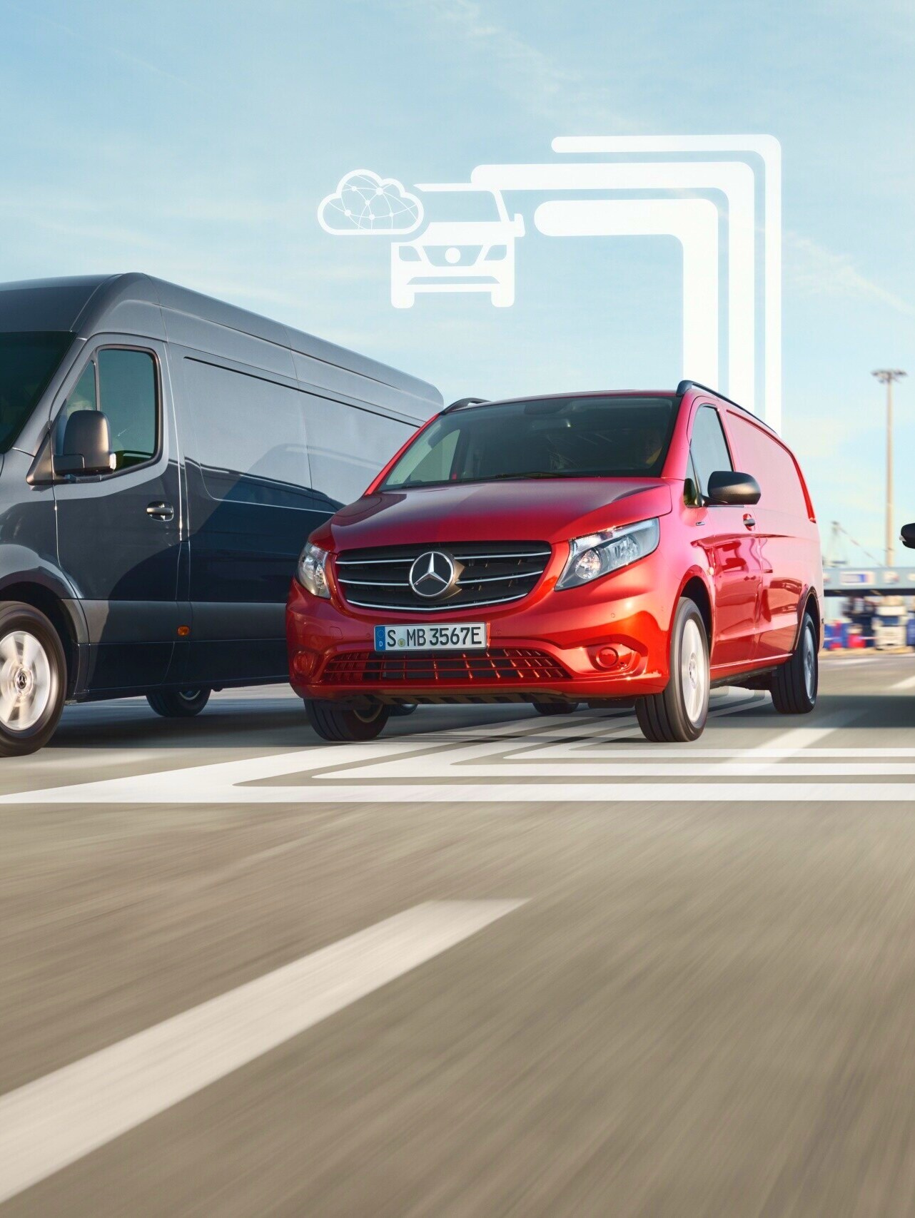Three employees standing in front of a silver Mercedes-Benz eSprinter with charging cable attached.