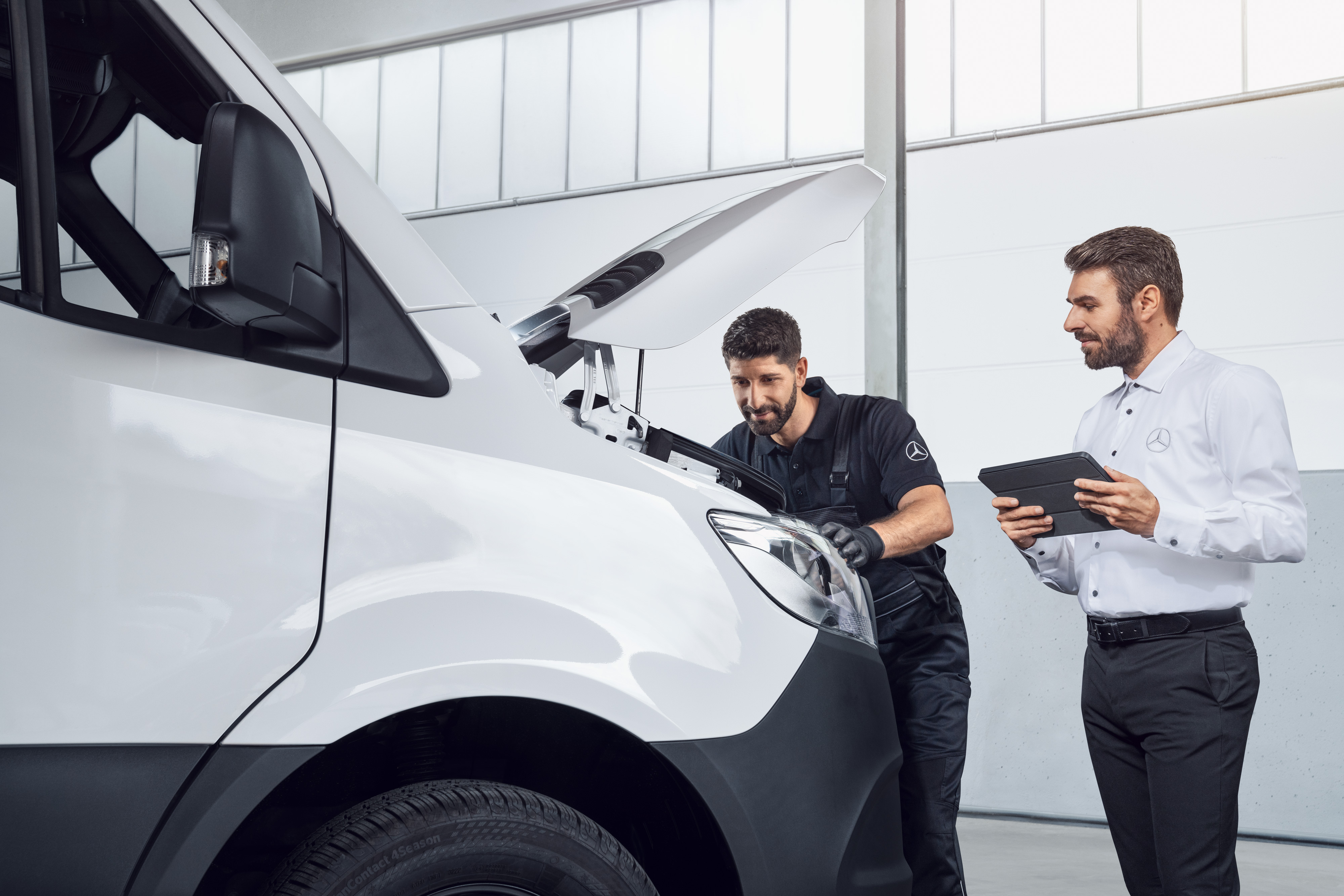 Mercedes-Benz | Vans Quality GenuineParts Two men testing a Mercedes Sprinter with tablet and open bonnet, topic: Mercedes-Benz Sprinter spare parts.