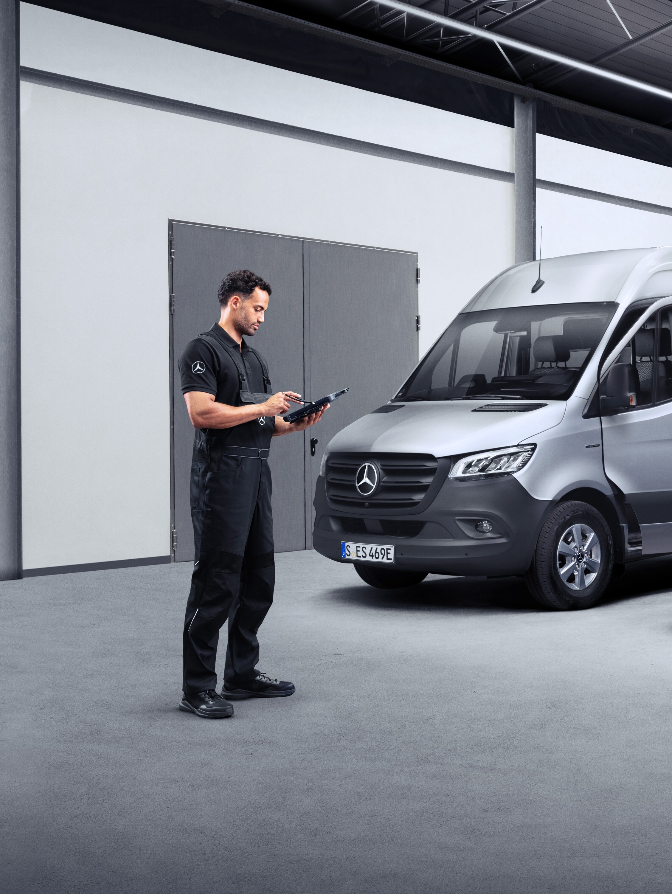 A technician infront of two eVans on a tablet