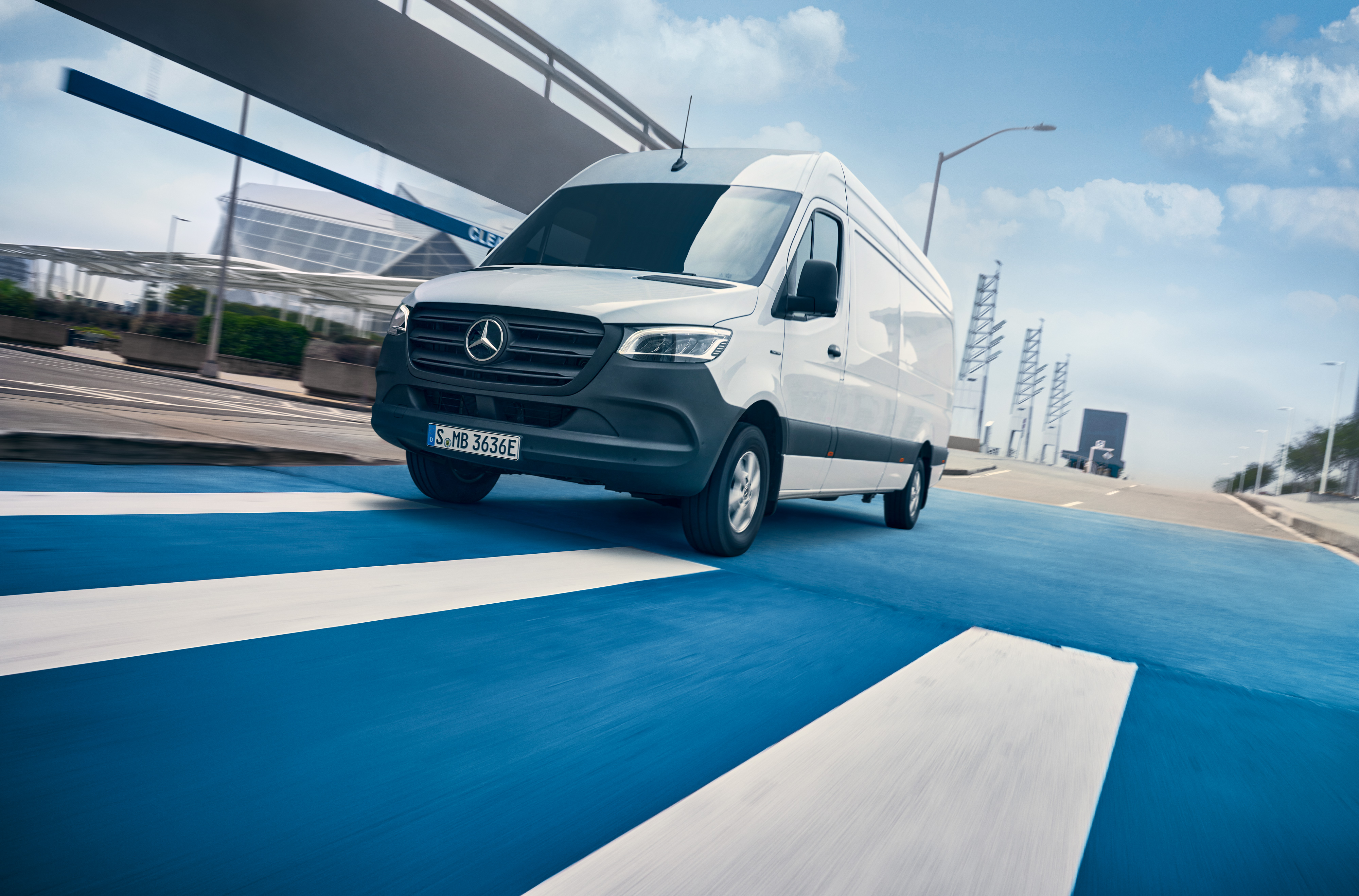 Mercedes-Benz | Van ServiceCare | Maintenance package A white Mercedes-Benz Sprinter drives on a road through a city.