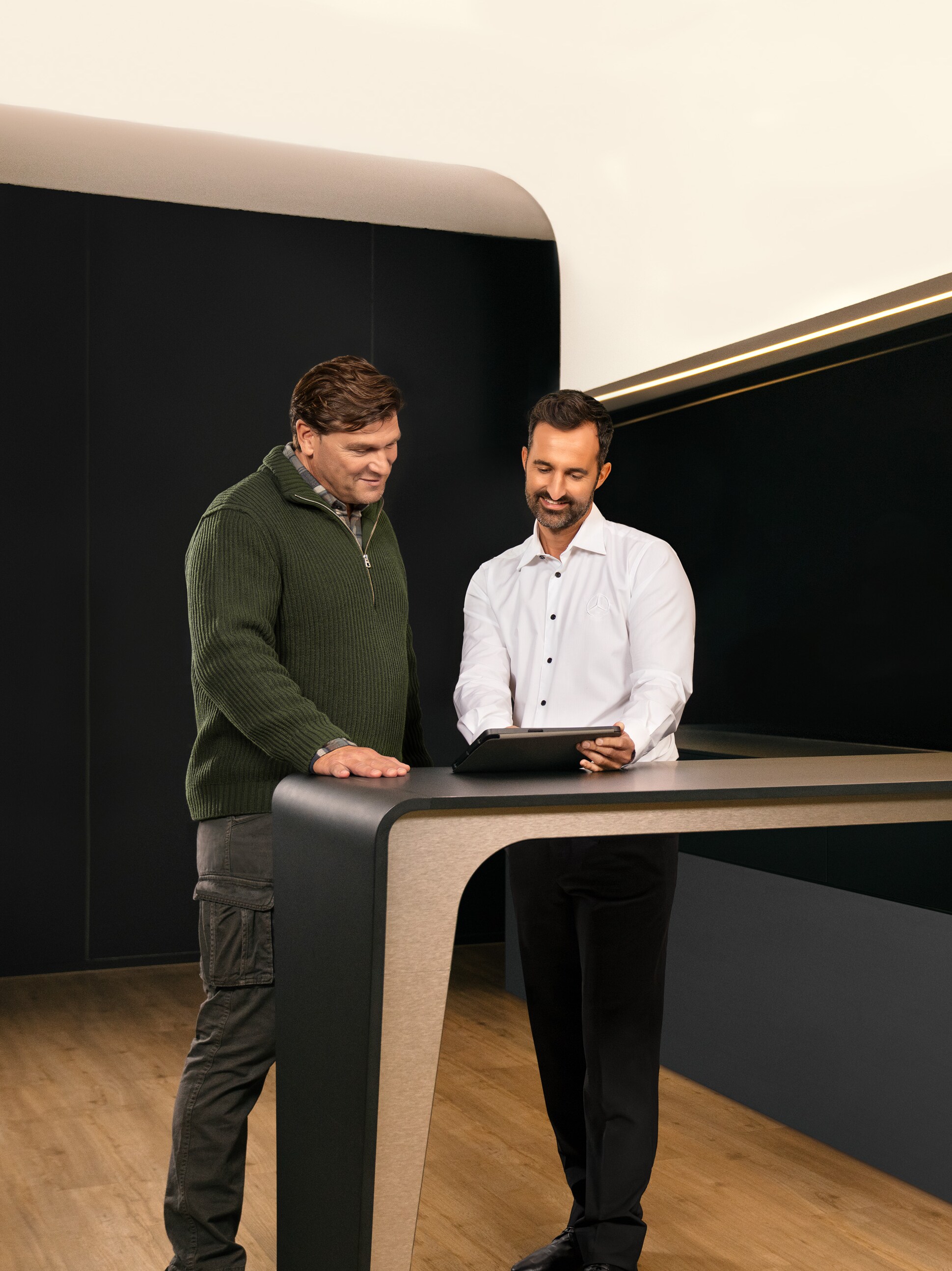 Two Men discussing commercial vehicle Service from Mercedes-Benz over a Tablet.