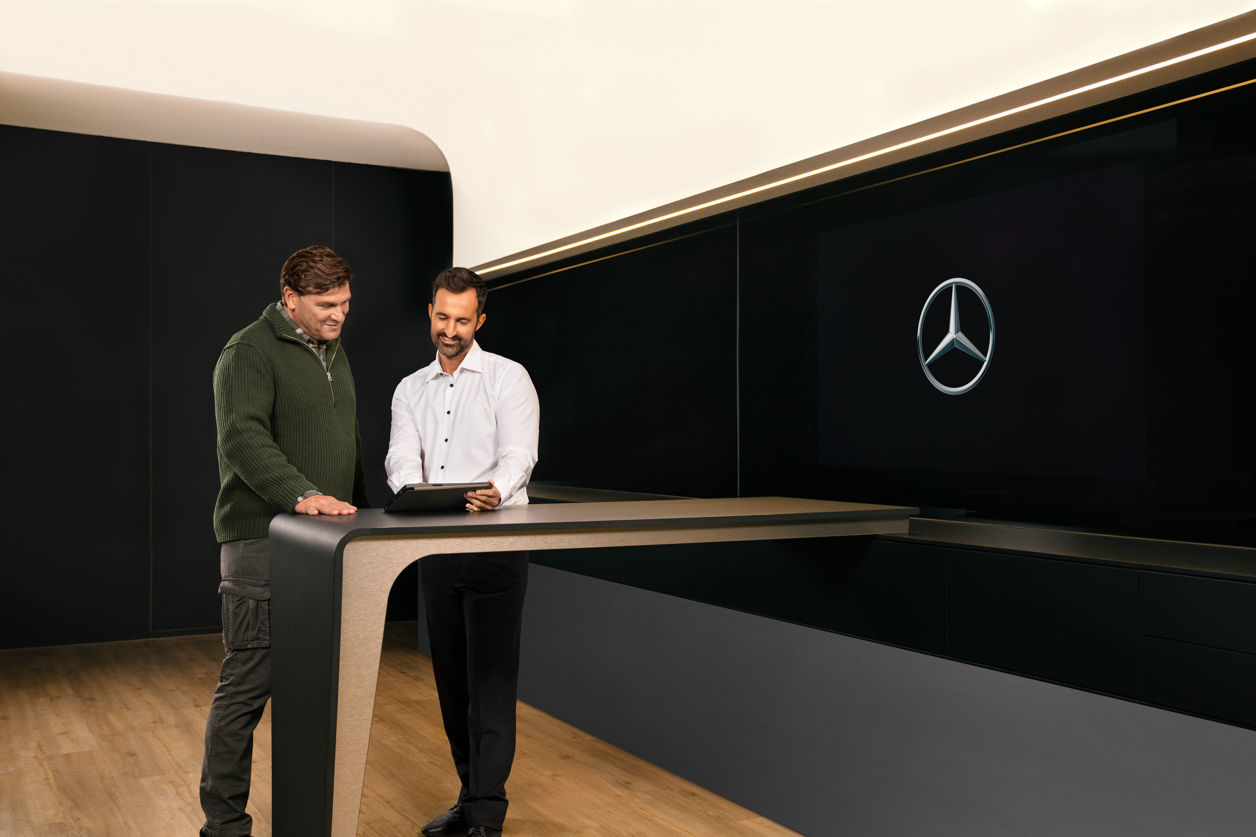 Mercedes-Benz | Services Overview | ServiceCare Two Men discussing commercial vehicle Service from Mercedes-Benz over a Tablet.