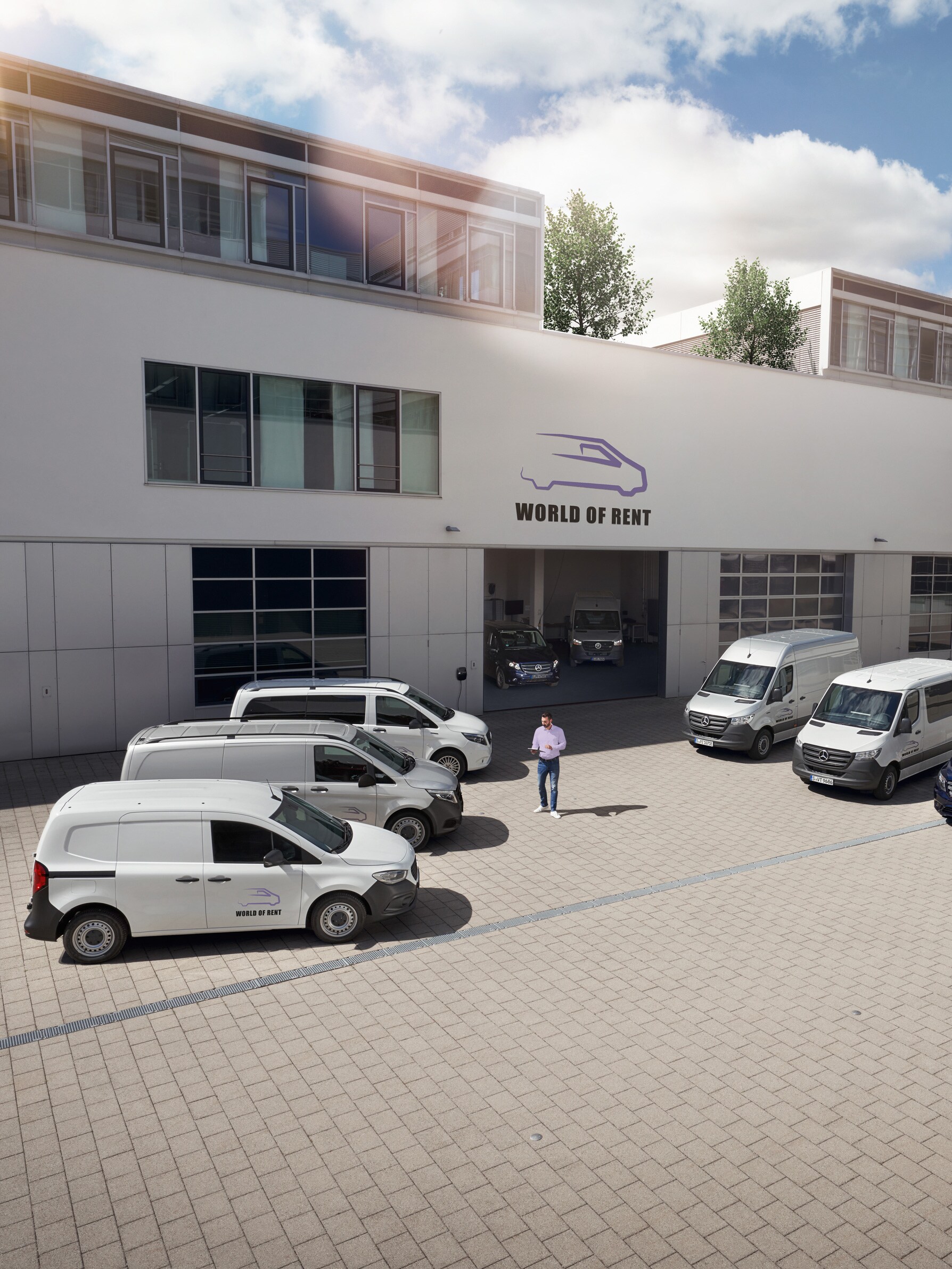 A fleet of Mercedes-Benz vans in front of a company building.