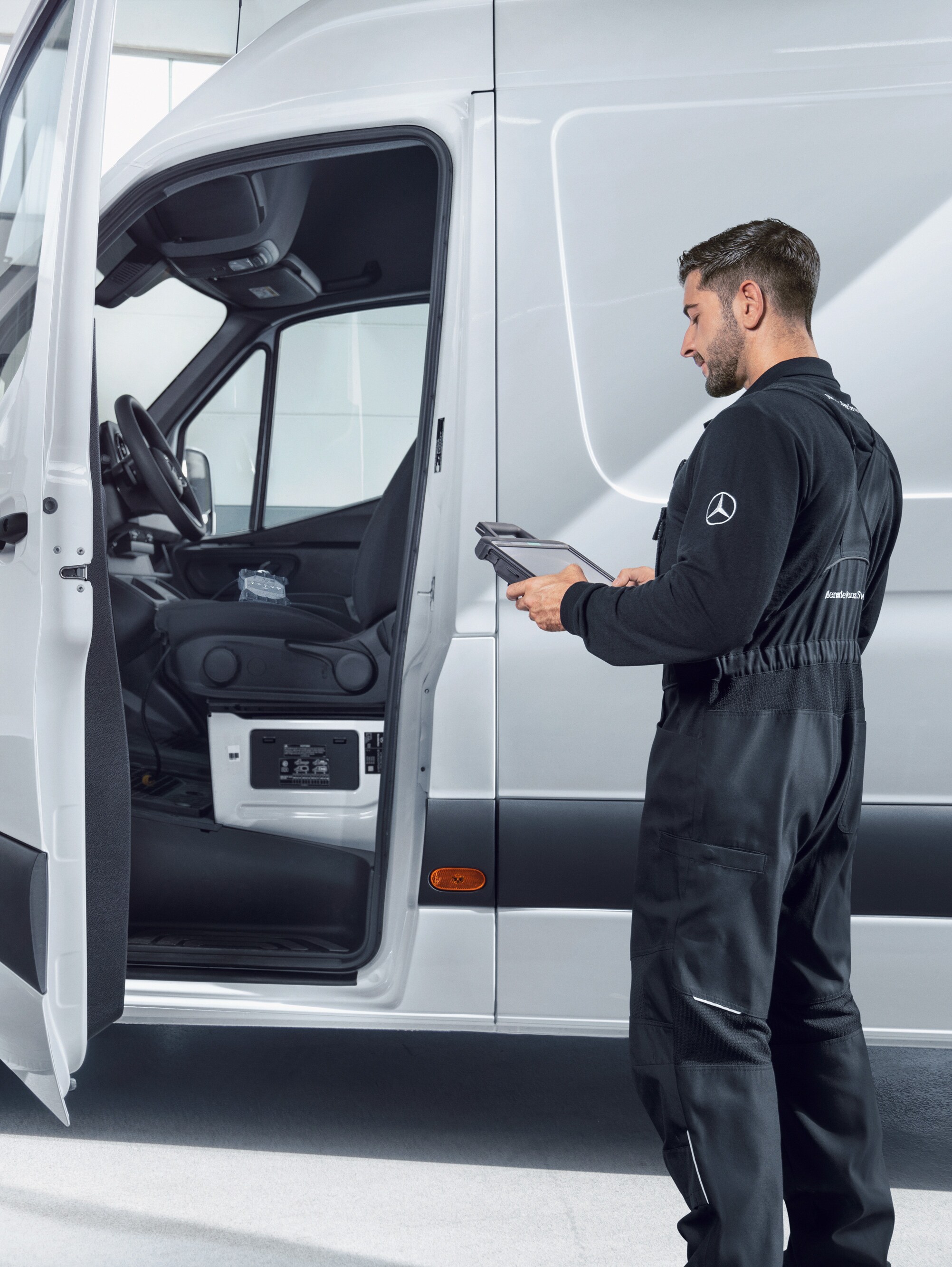 An employee inspecting a Mercedes-Benz van providing reliable service quality for maintenance and repairs.