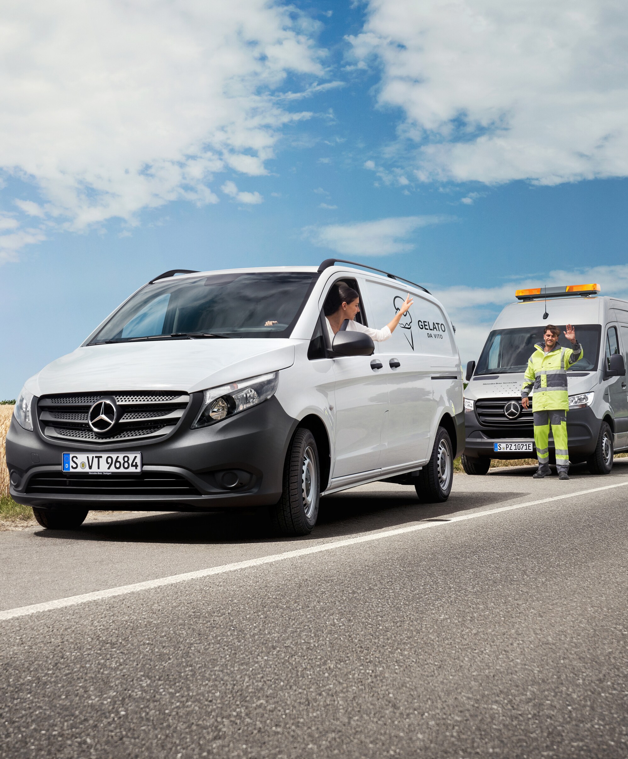 A mechanic providing roadside assistance to customer in a white Mercedes-Benz  Vito van.
