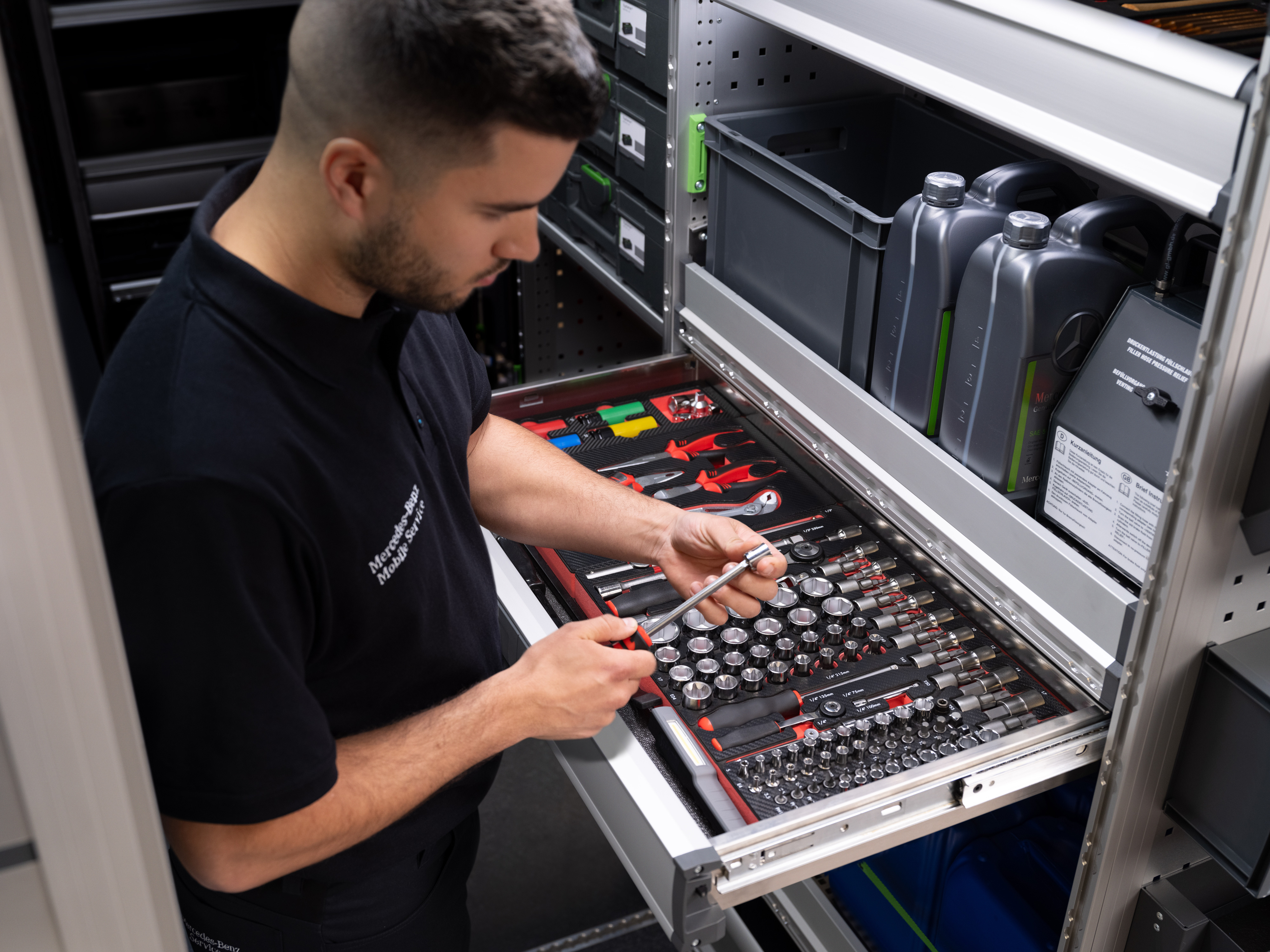 Mercedes-Benz | Mobile Service | Electronics A technician selects an item from a draw full of tools.