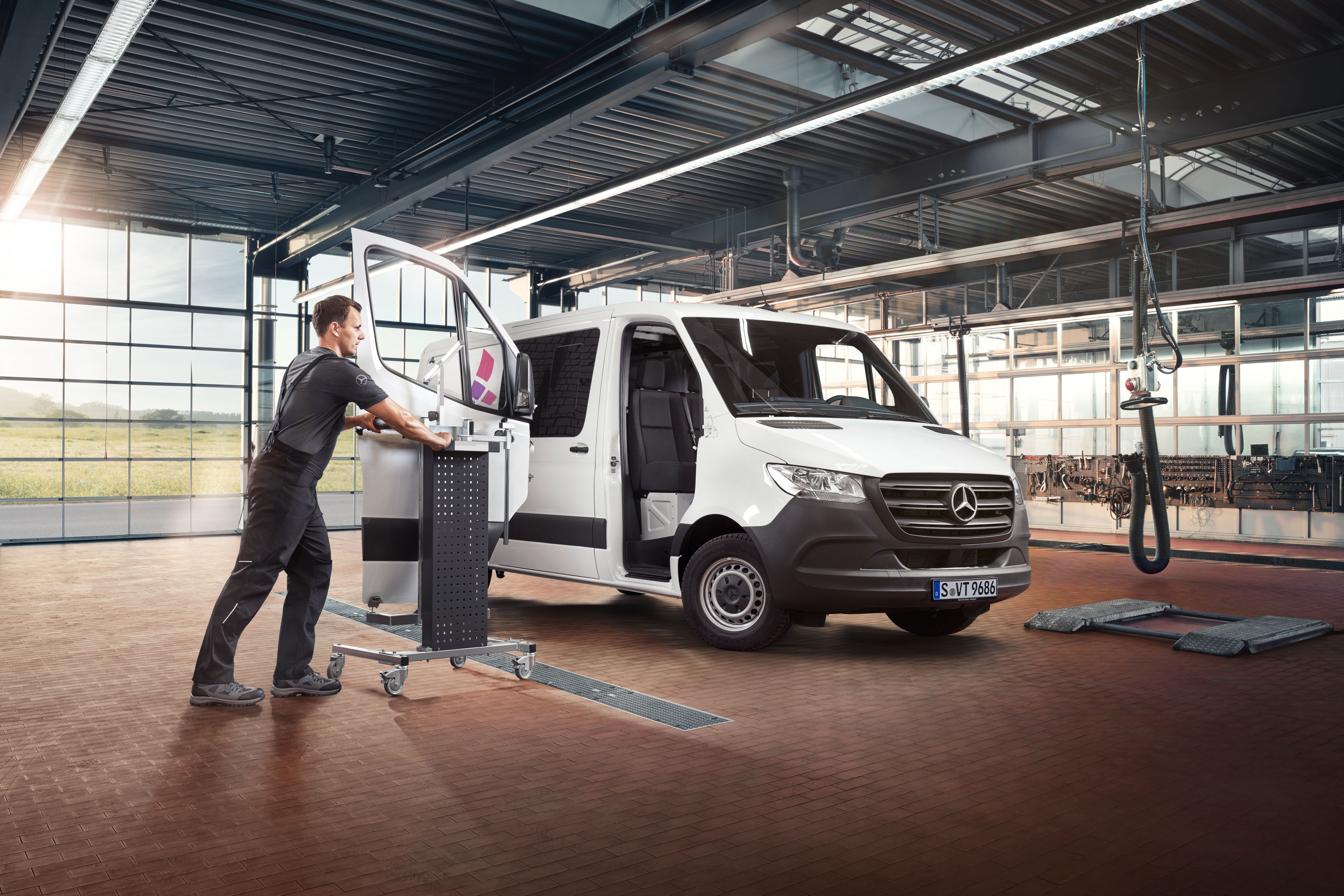 Mercedes-Benz | Repair Mechanic fitting the door on a white Mercedes-benz Sprinter.