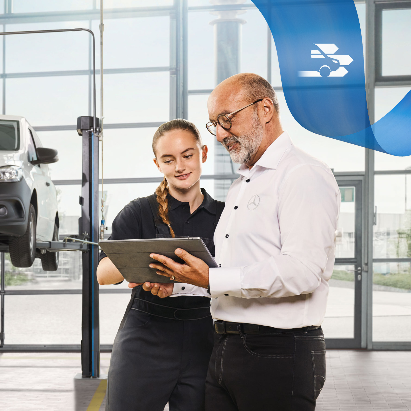 Mercedes-Benz | Maintenance Two employees discuss the commercial vehicle service on a jacked-up Mercedes-Benz van in the workshop.