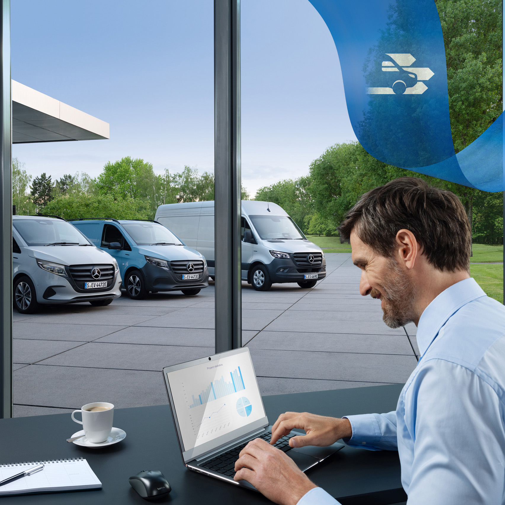Mercedes-Benz | Van ServiceCare A man is using a laptop in an office with a range of Mercedes-Benz vans in the background.