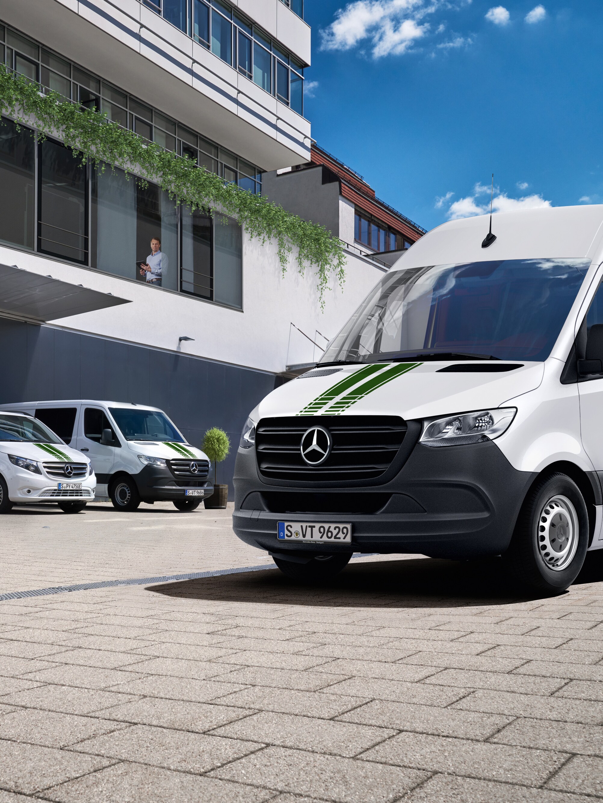 A fleet of Mercedes-Benz vans in front of a building, symbolising digital fleet monitoring.