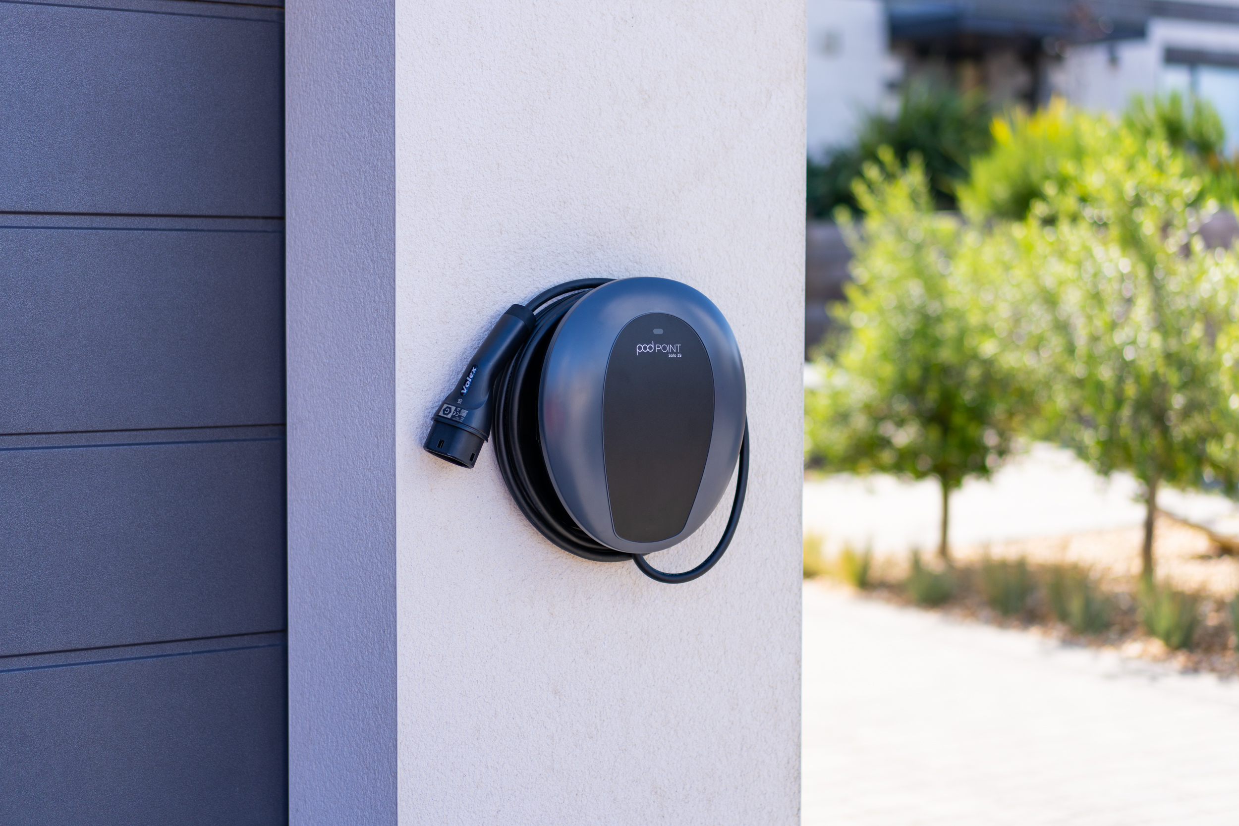 Charging at home | Charging & Services | Mercedes-EQ EV charging wall box on wood panel wall