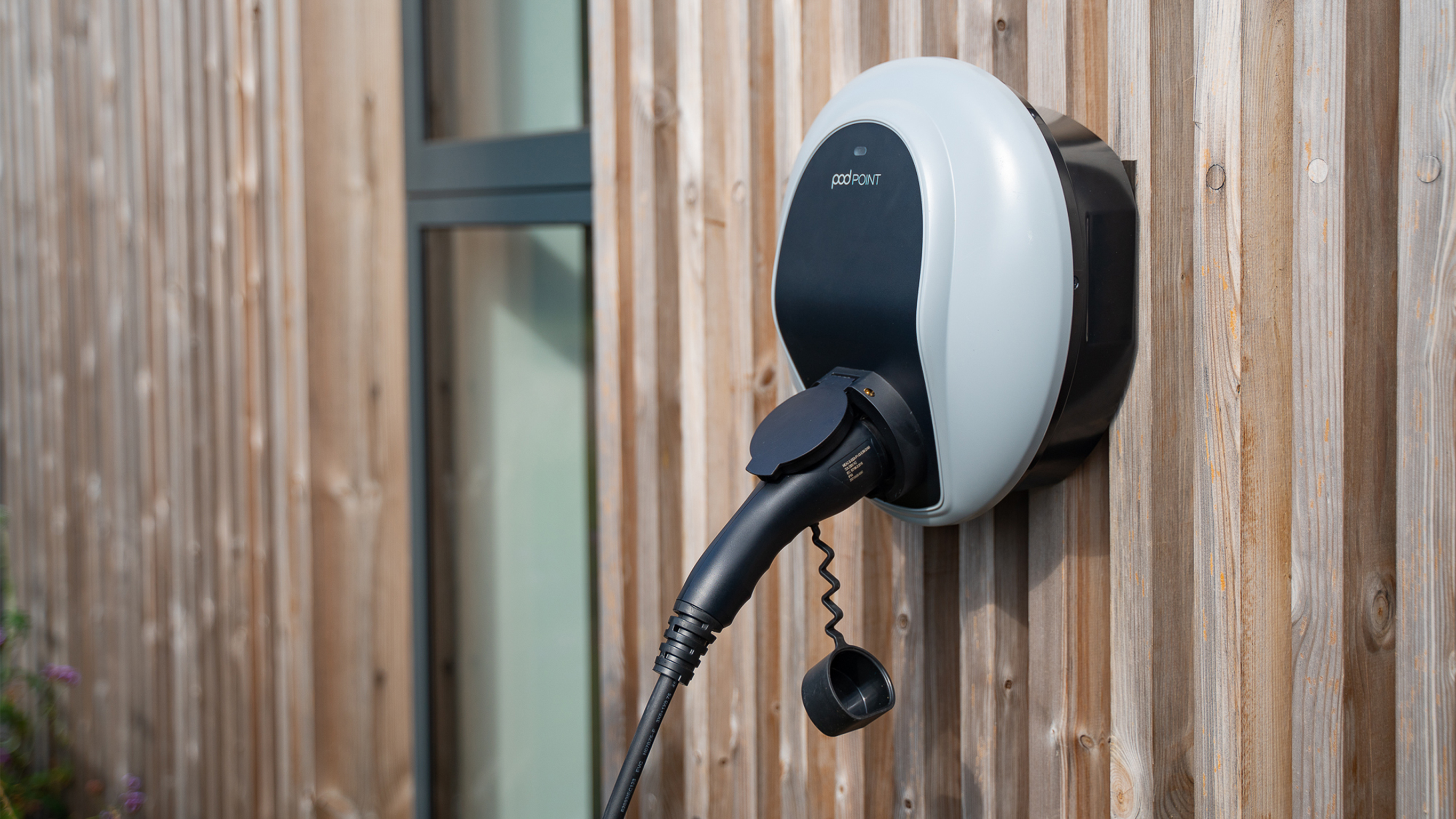 Charging at home | Charging & Services | Mercedes-EQ EV charging wall box on wood panel wall