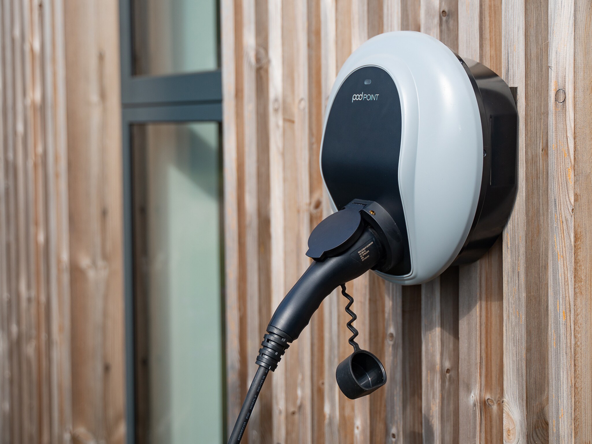 EV charging wall box on wood panel wall