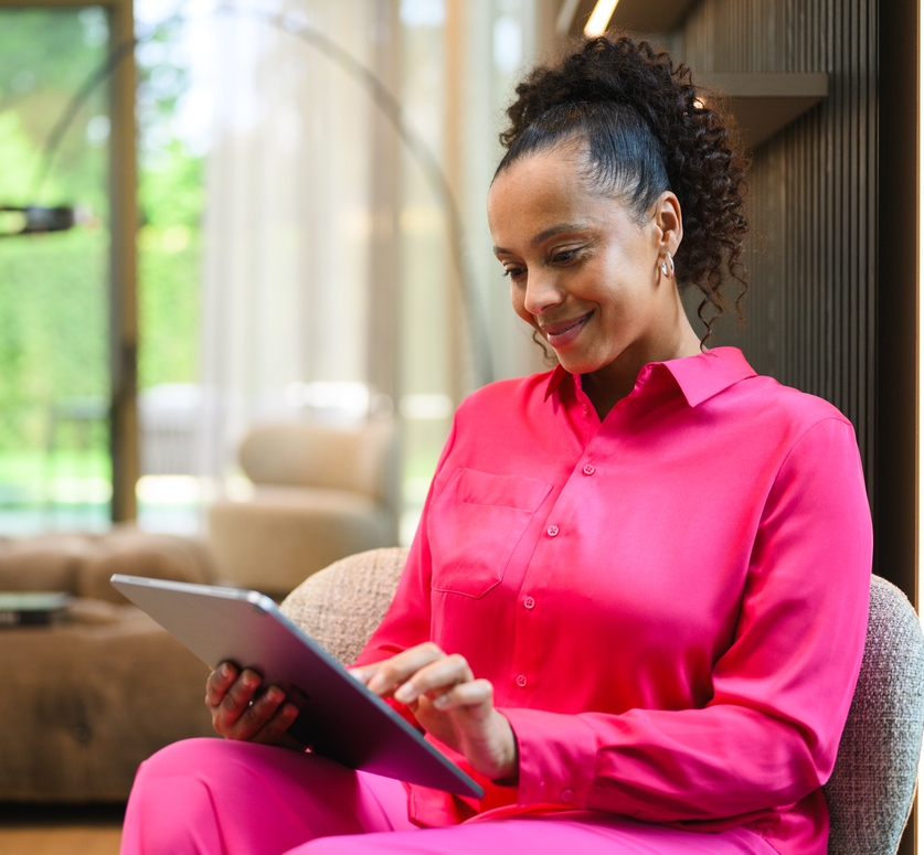 Mercedes-Benz Finance Portal A person at home looking at a tablet device and smiling.