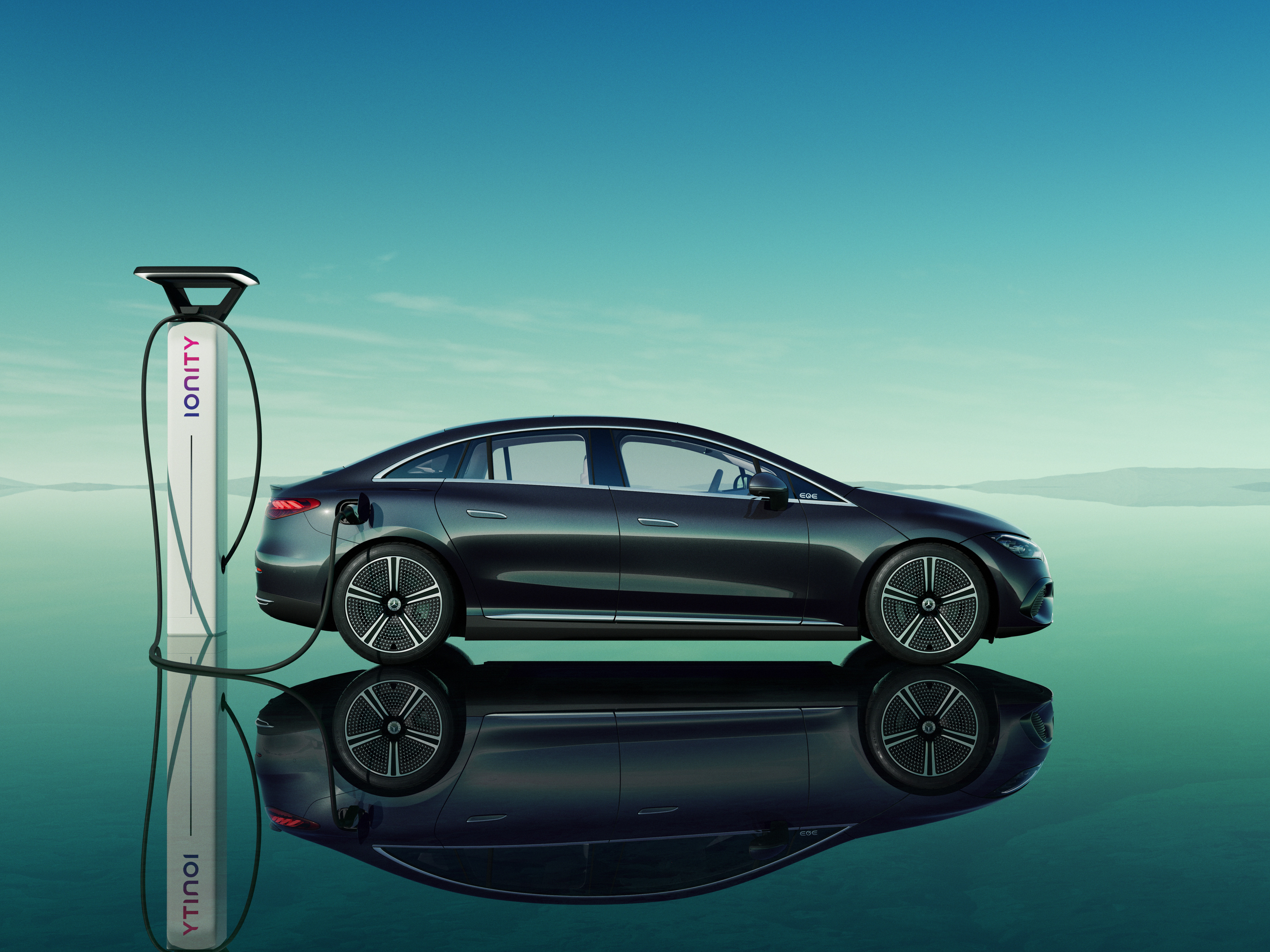 Black Mercedes-Benz Ionity charging against teal reflective backdrop Black Mercedes-Benz Ionity charging against teal reflective backdrop