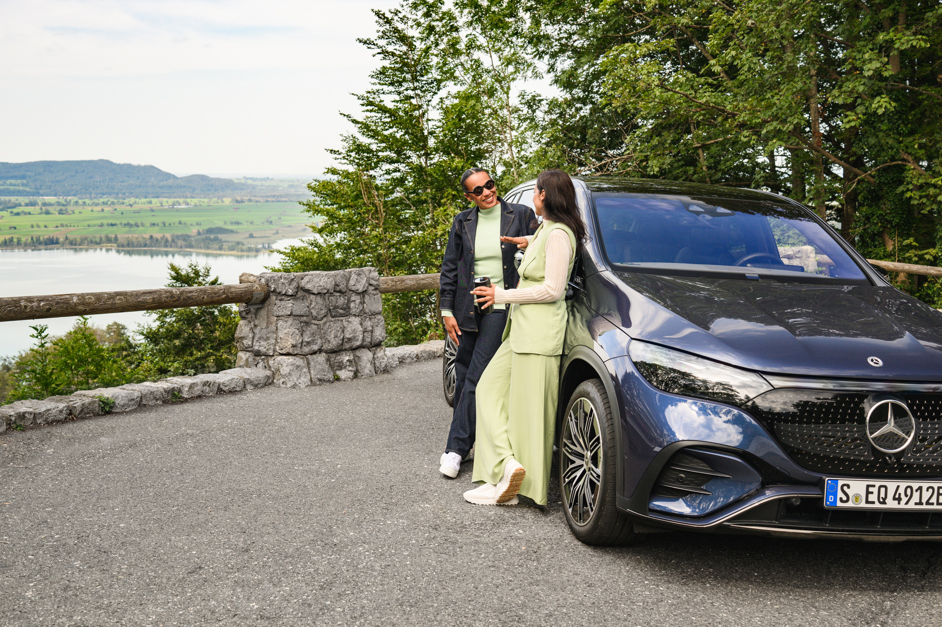 Existing Customers Title Two people stood next to their Mercedes-Benz near a lake.