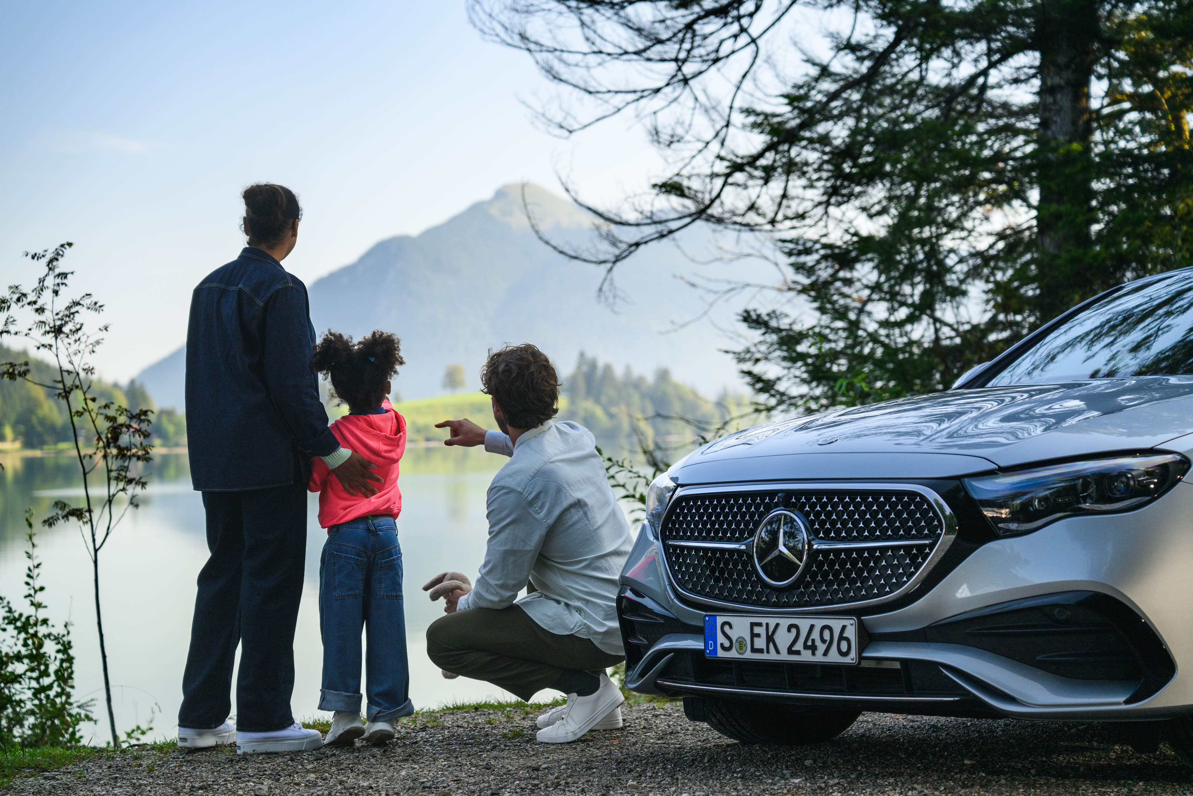 Finance Products A family looking across a lake next to a Mercedes-Benz.