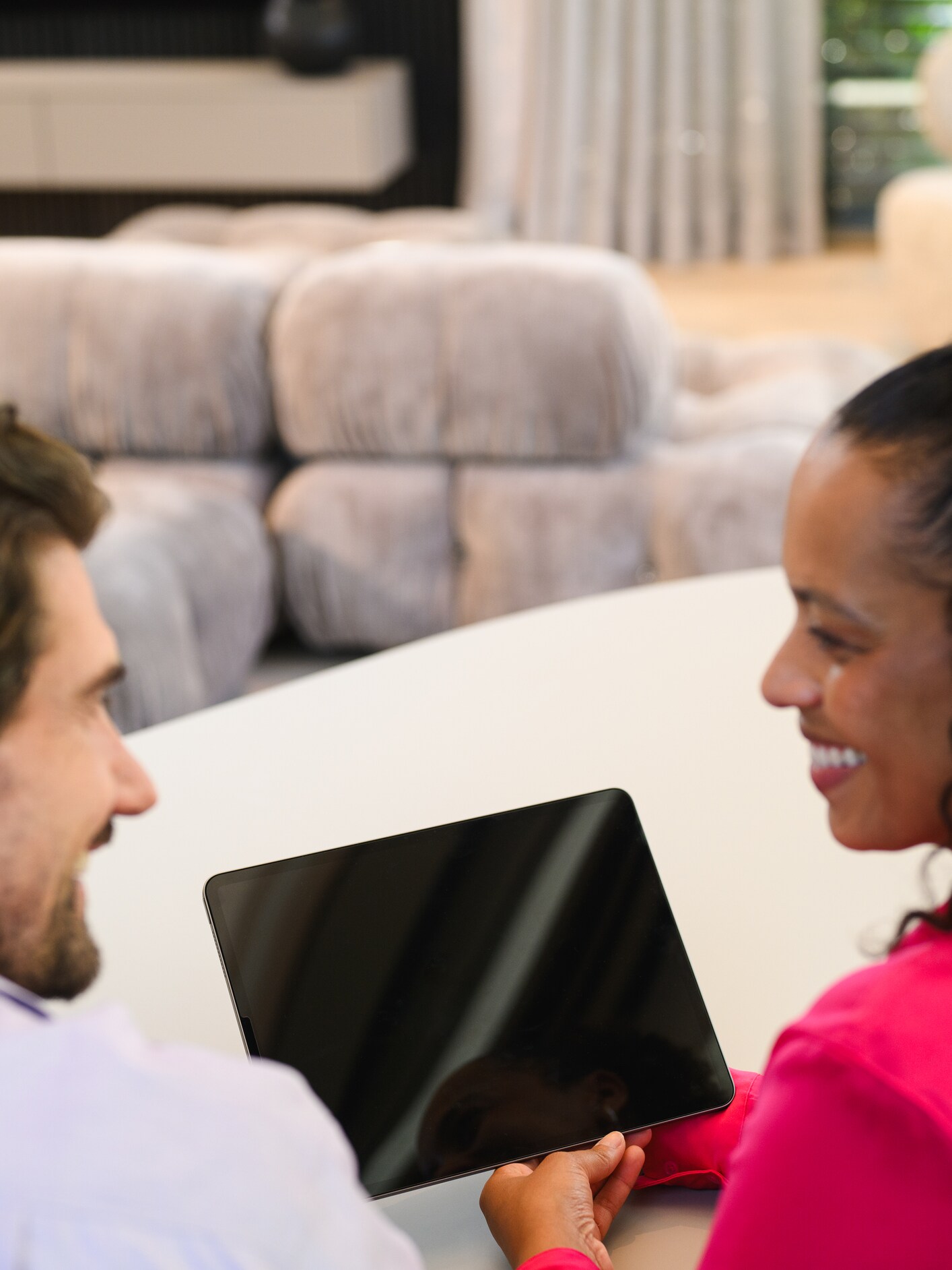 Two people looking at a tablet device.