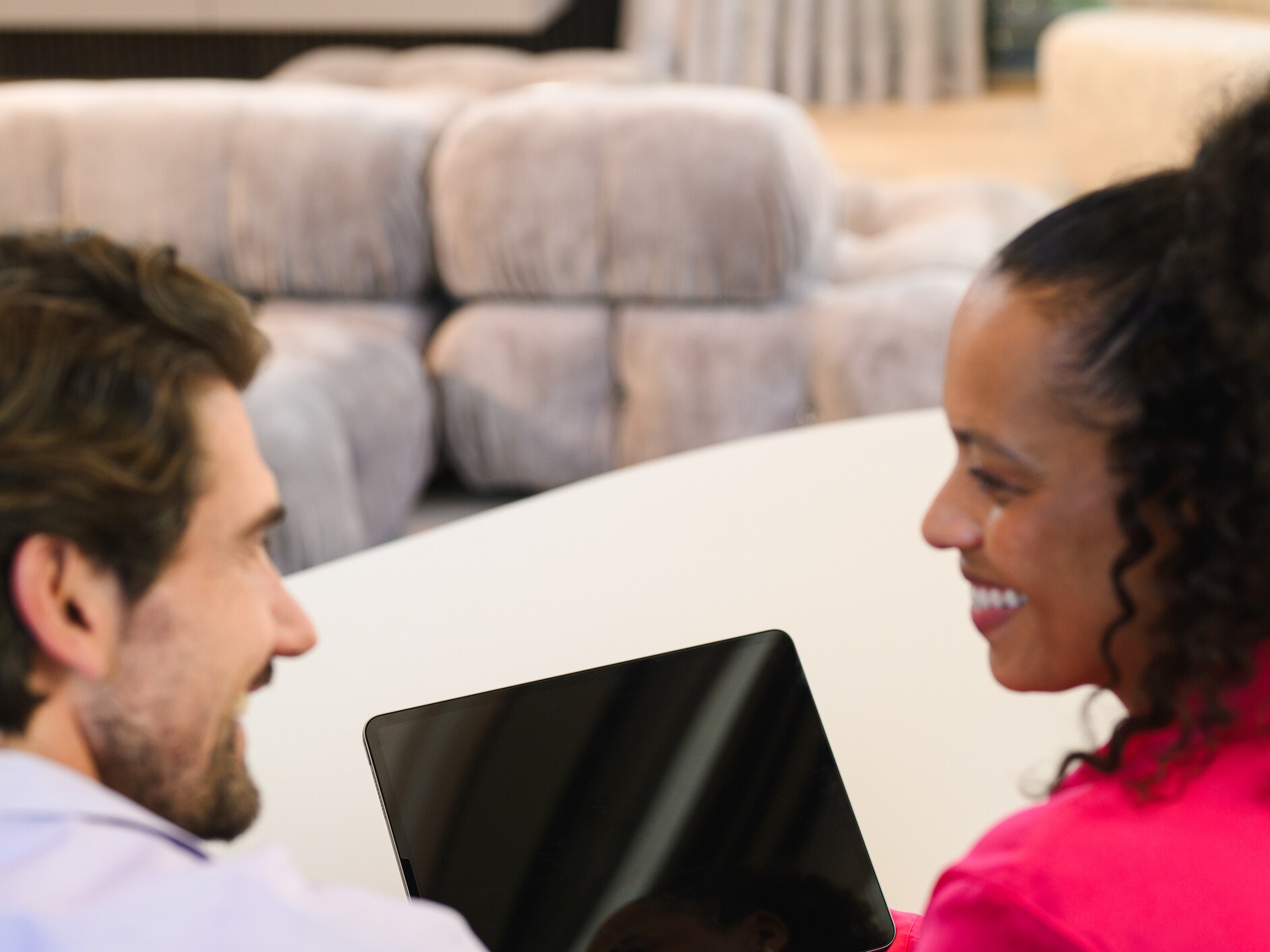 Couple at home smiling over a laptop.