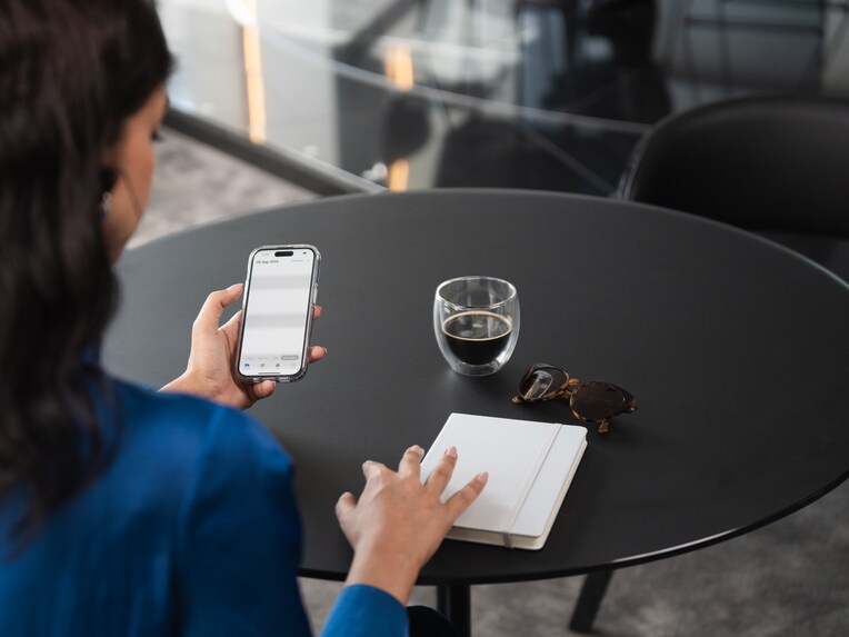A Person looking at her phone while sat in a dealership.
